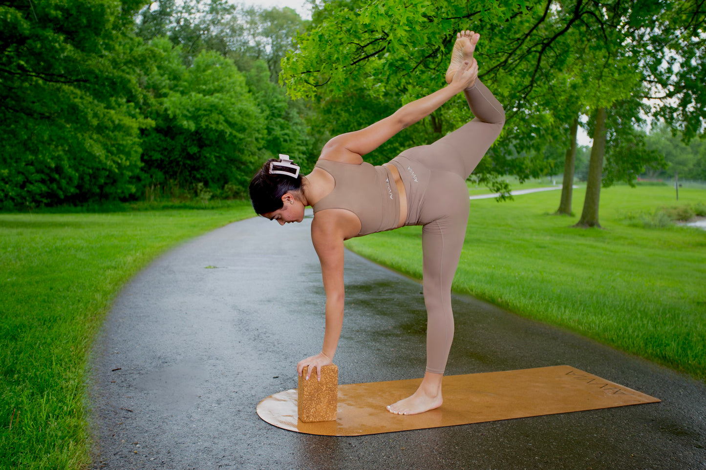 Woman balancing in dancerâs pose on a cork yoga mat, using cork yoga blocks for support.