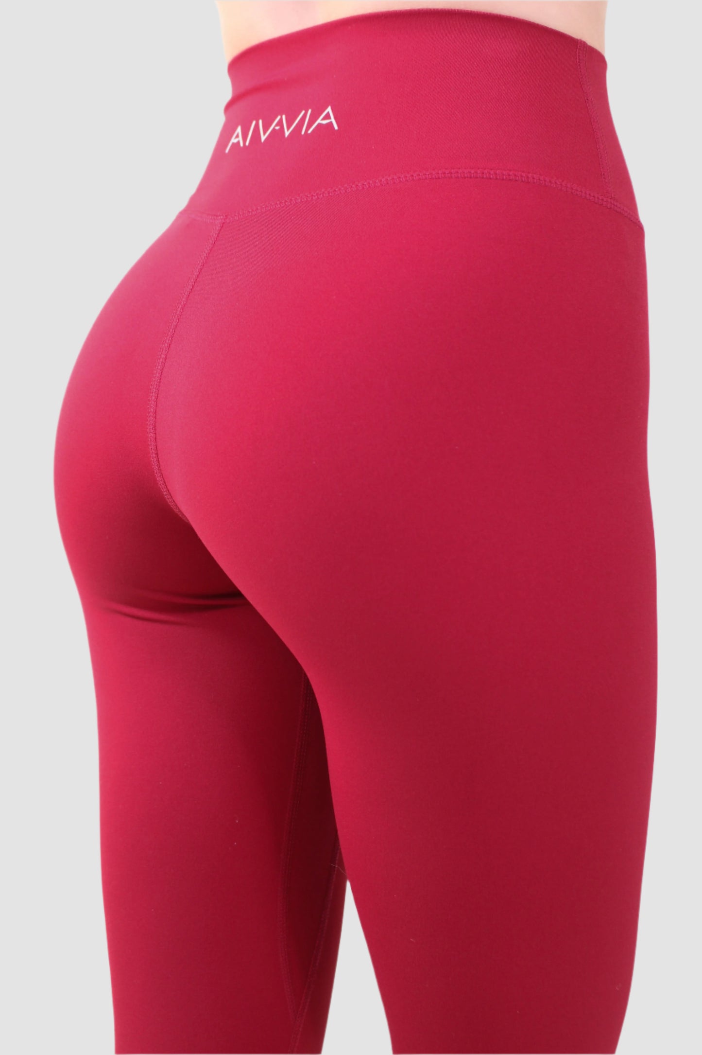 Close-up of Aivvia Athletics logo on red sports bra, showcasing premium stitching and support.