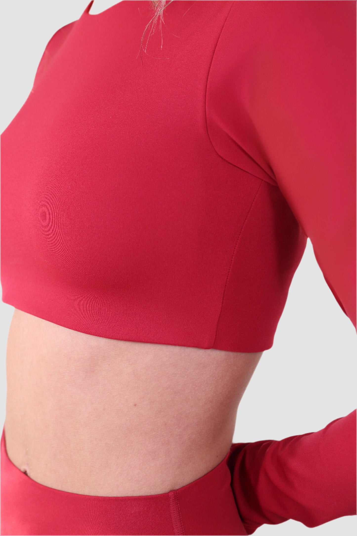 Side view of Aivvia Athletics red long sleeve sports bra with stretch fabric and body-contouring design for workouts.