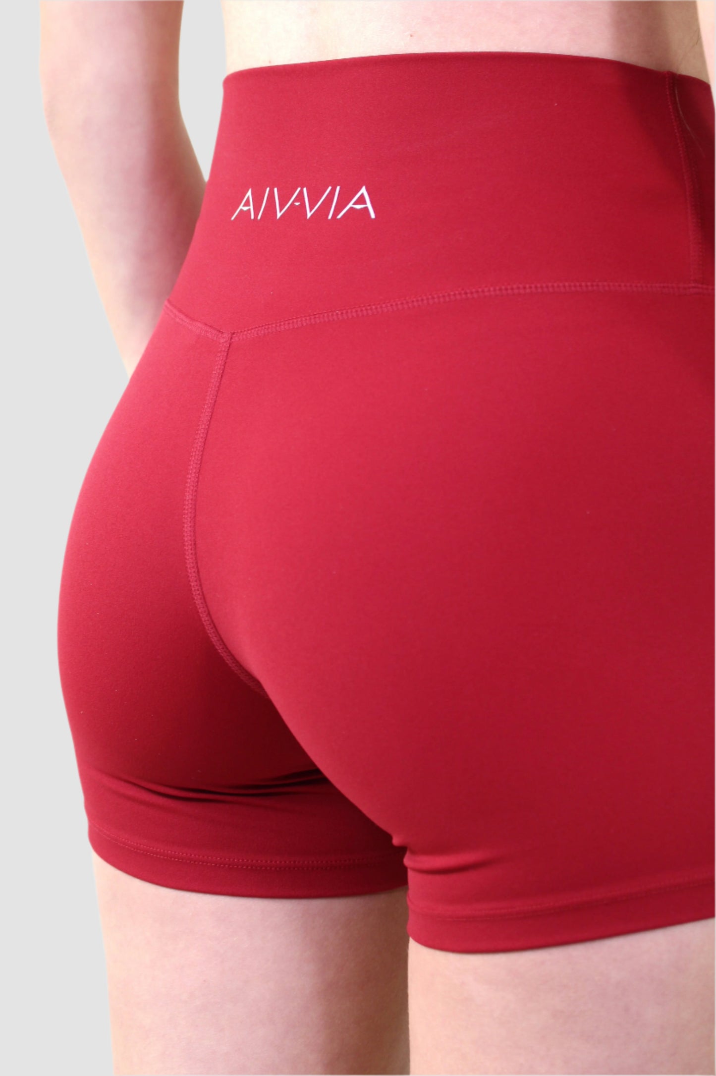 Back close-up of red Aivvia Athletics shorts featuring contour seams and minimal logo design.