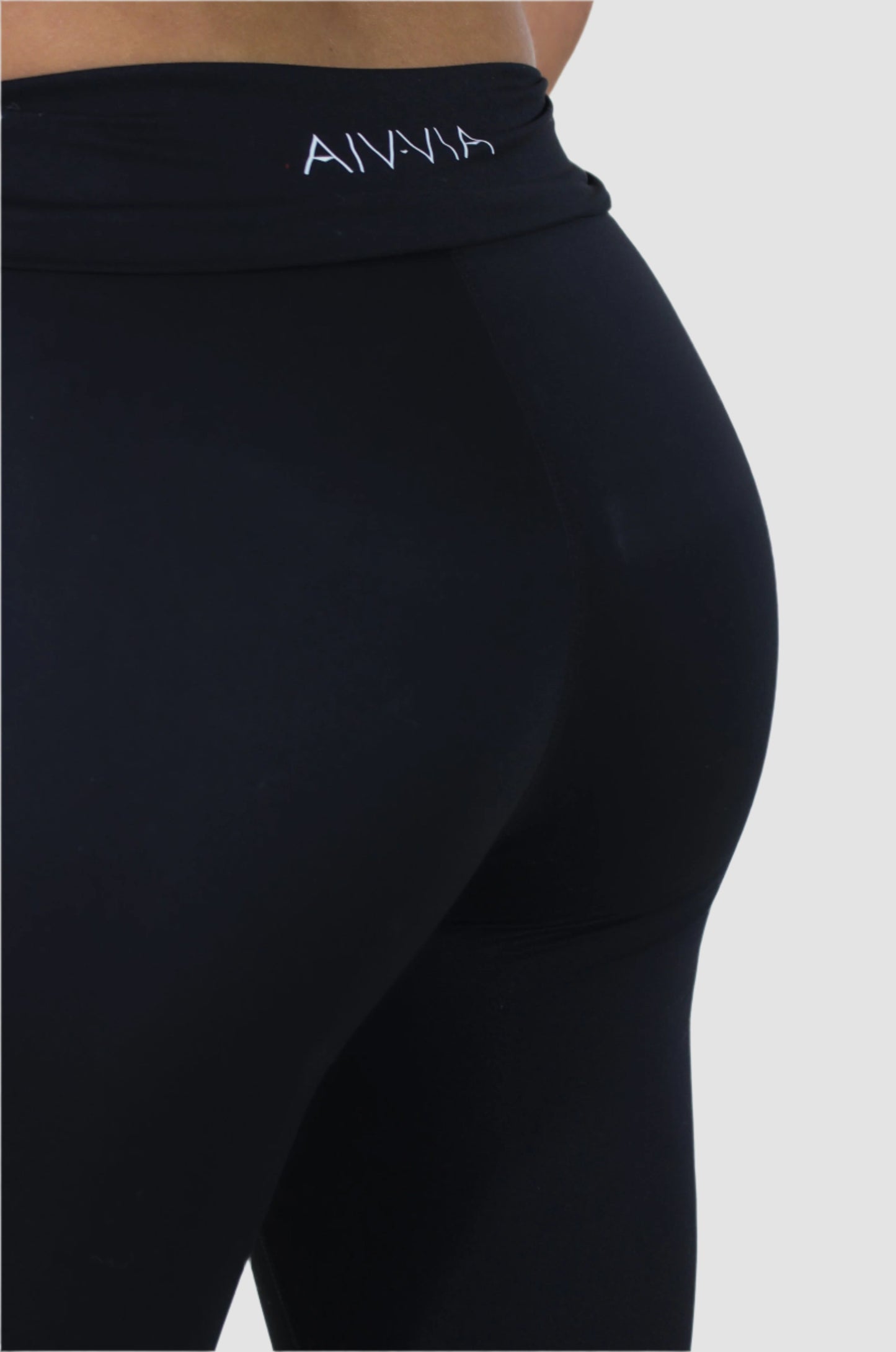 Close-up back view of black Aivvia Athletics flared yoga pants with logo detail, soft and form-fitting fabric.