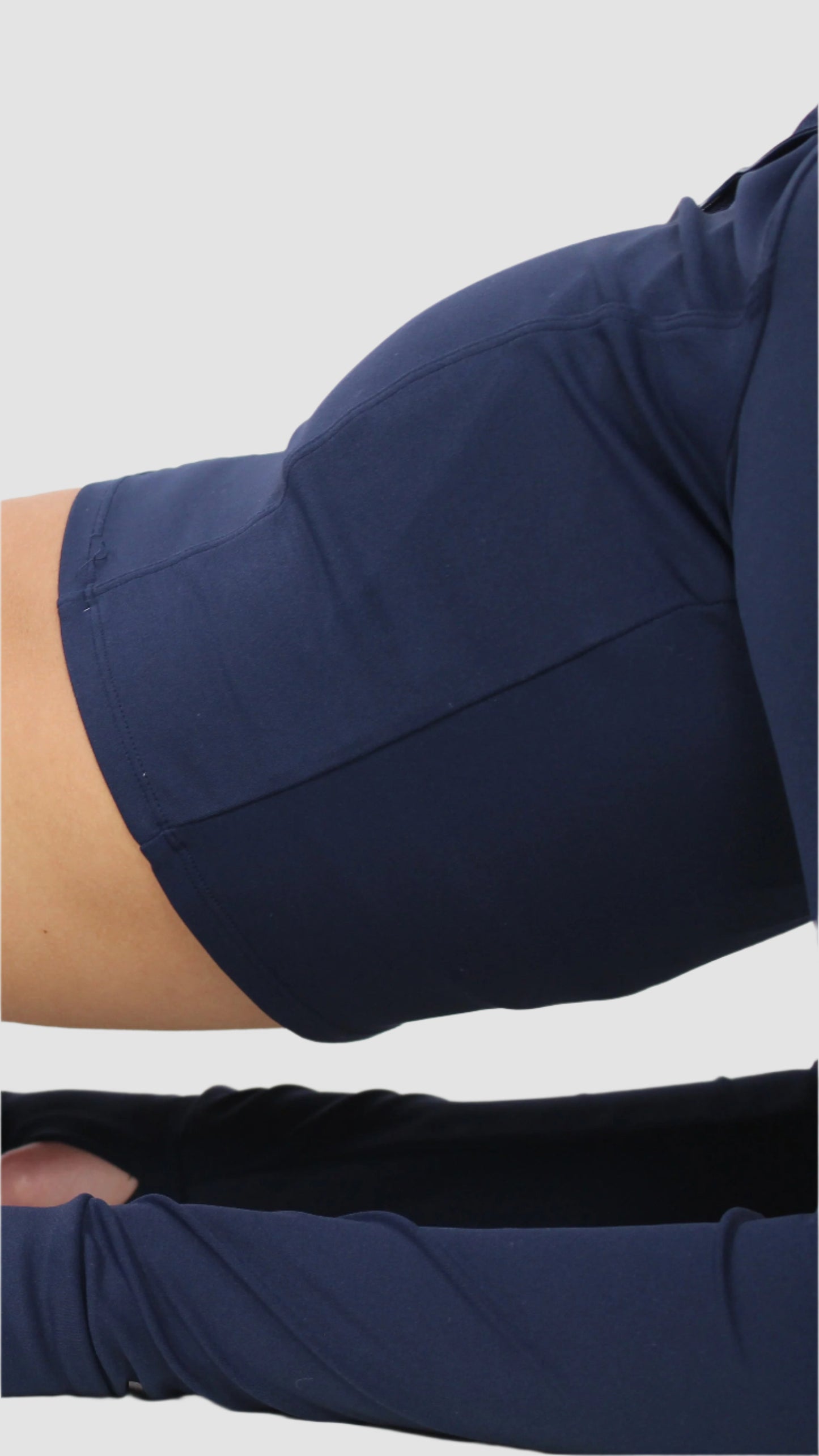 Close-up of navy Aivvia Athletics zip-up jacket sleeve, showing smooth stretch fabric and stitching detail.