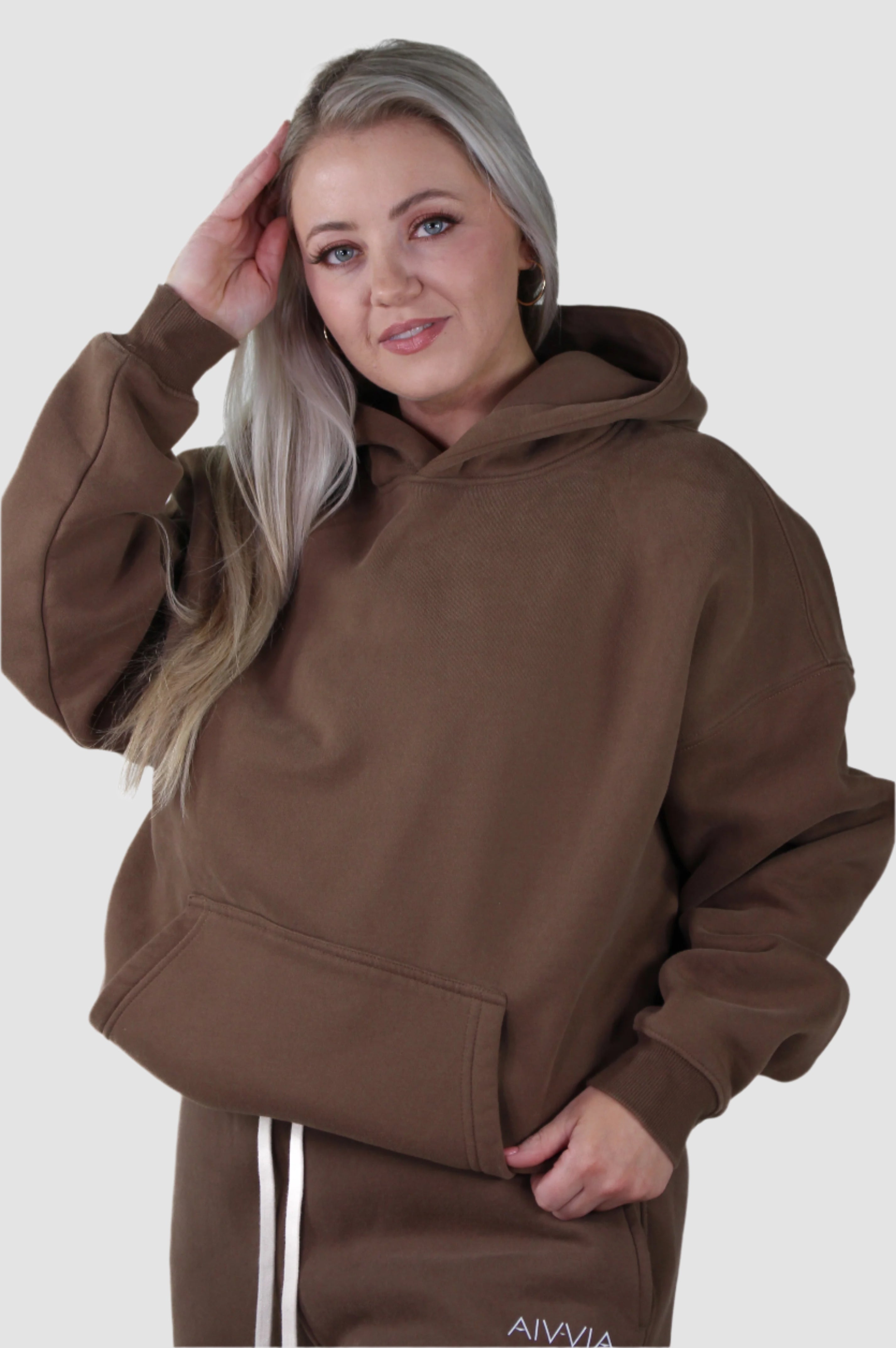 Brown Aivvia Athletics hoodie with hood up, relaxed women’s sportswear for active lifestyle.
