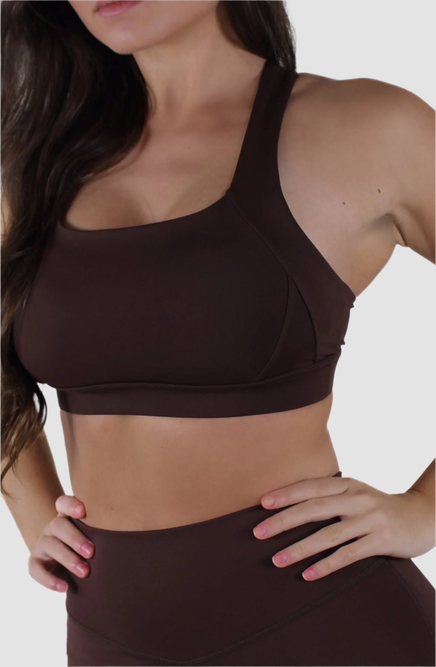 Close-up of brown Aivvia Athletics sports bra showing scoop neckline and supportive design.