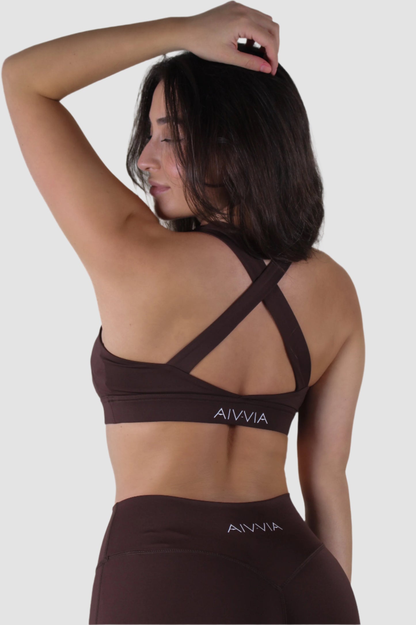 Brown Aivvia Athletics sports bra with criss-cross back straps and logo detail at the band.