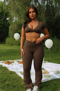 Front view of the Mocha Brown Nova Twist Crop Tee from AIVVIA Athletics, designed in ultra-soft, second-skin fabric that contours and flatters the body. This crop top features a stylish twisted front detail, short sleeves, and a sculpting, form-fitting cut for both comfort and performance. Perfect for layering or wearing on its own, the Nova Twist Crop Tee pairs seamlessly with leggings, shorts, or the matching Nova set, making it a versatile choice for yoga, Pilates, strength training, and everyday athleis