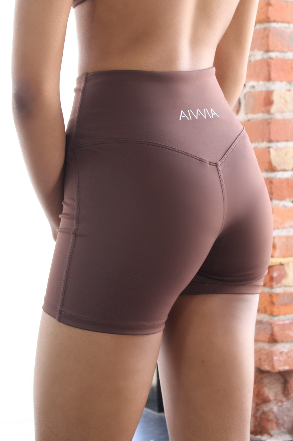 Back view of chocolate brown Aivvia Athletics shorts with glute-lifting contour seam and seamless sculpted finish.
