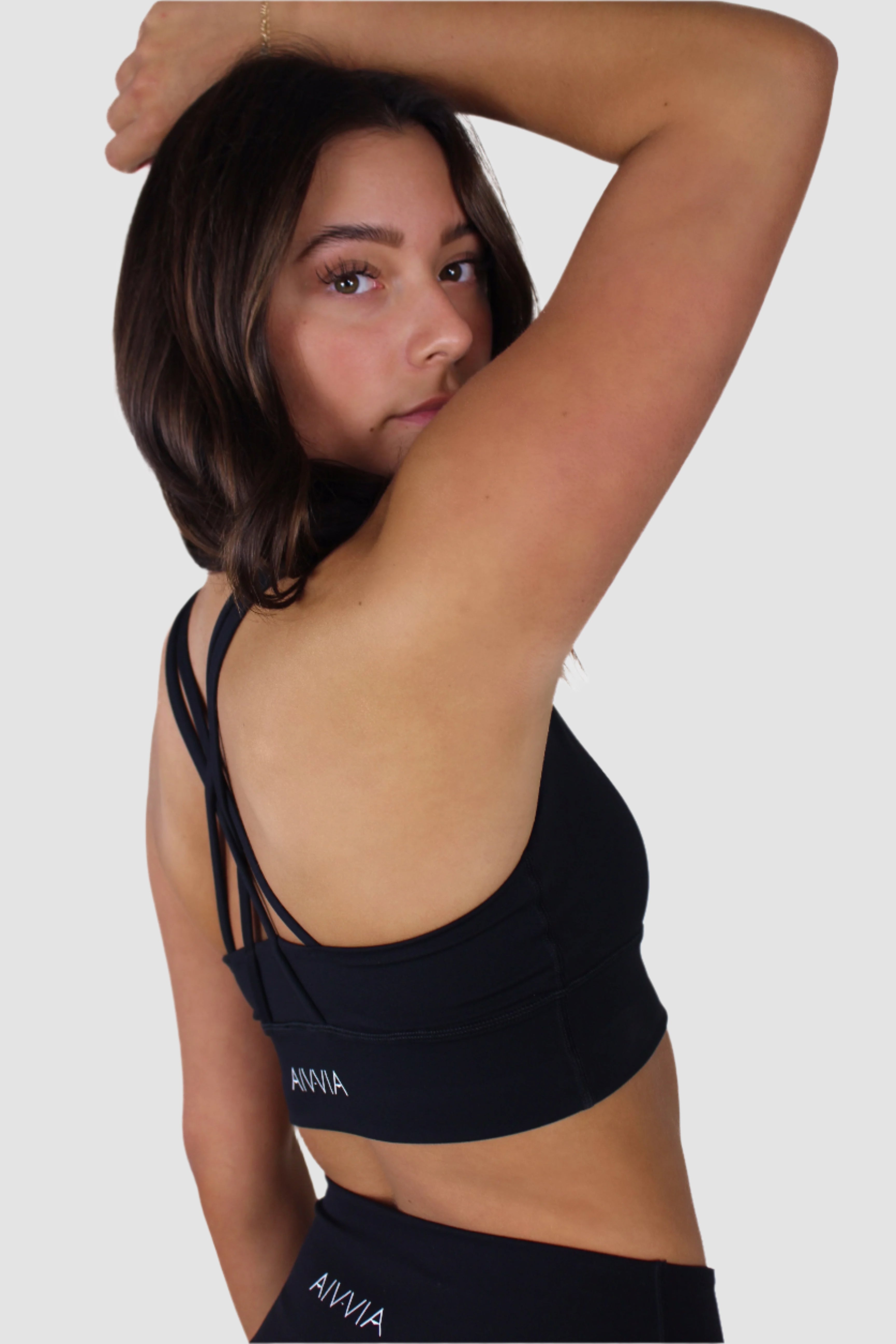 Side-back view of black Aivvia Athletics sports bra featuring thin cross-back straps.