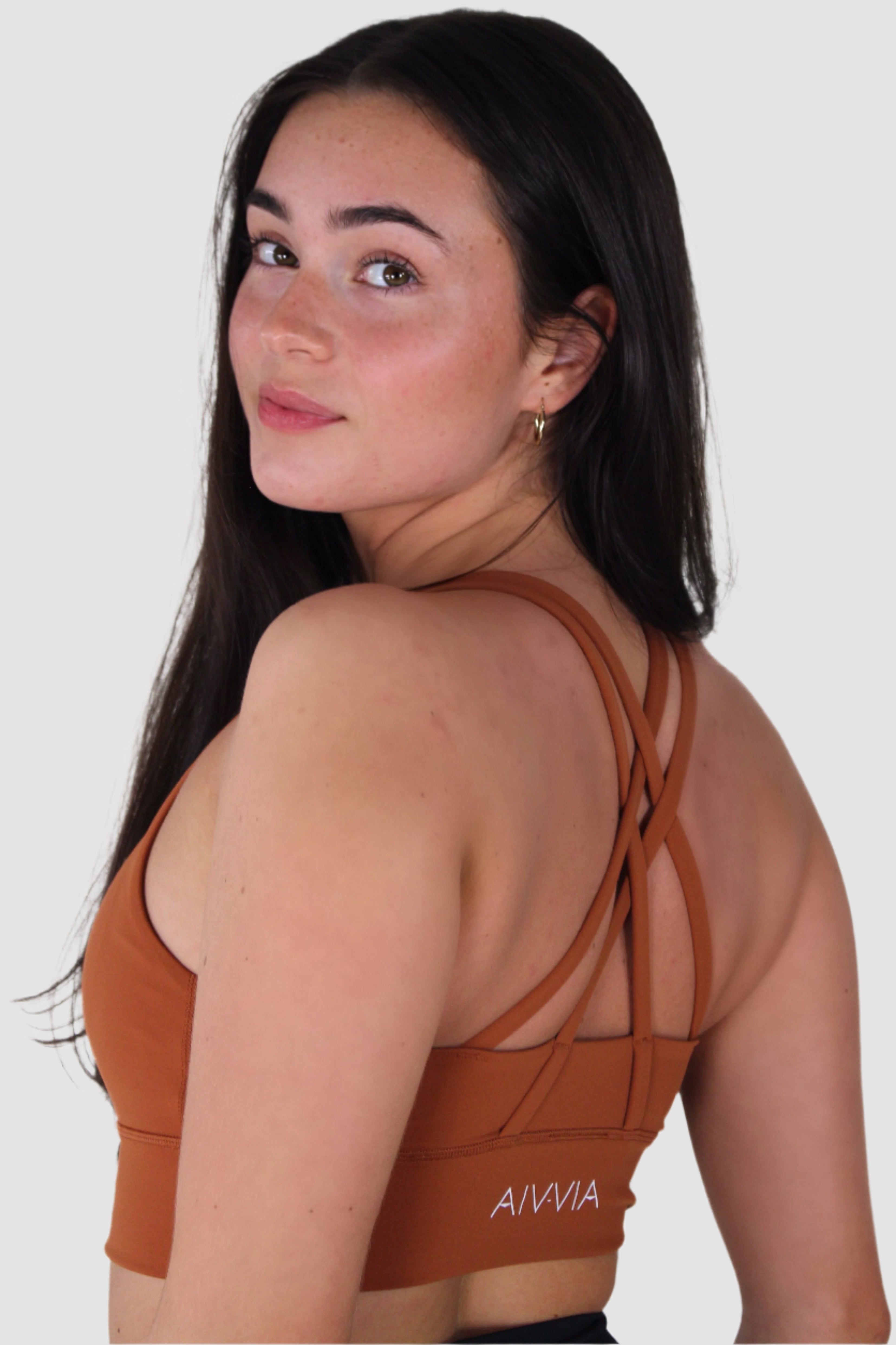 Front view of rust-colored Aivvia Athletics sports bra with scoop neckline and wide straps.