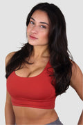 Front view of red Aivvia Athletics sports bra with scoop neckline, offering medium support and a smooth fit.