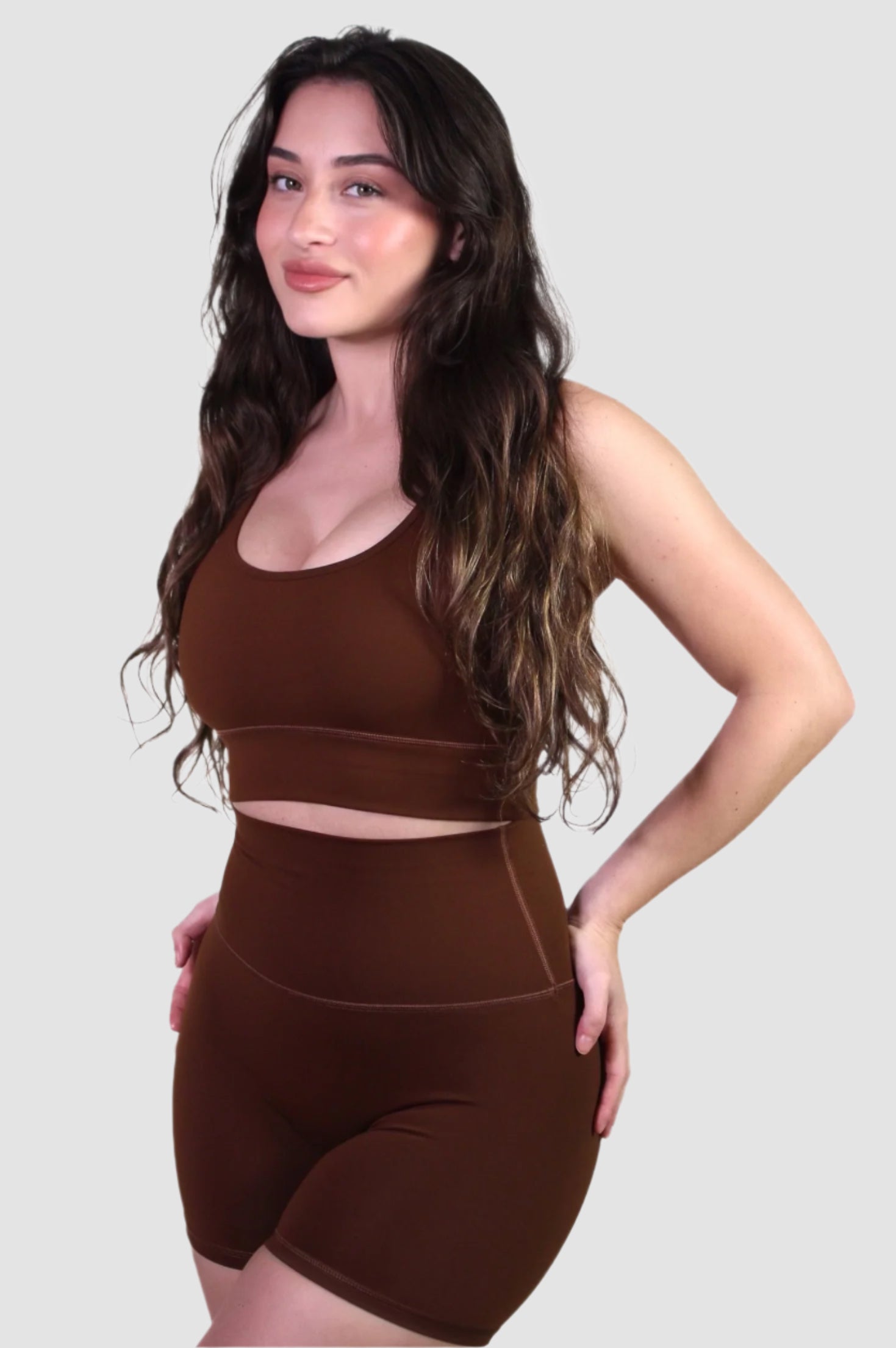 Side view of the chocolate brown activewear set, highlighting the snug, supportive fit of both the sports bra and shorts.