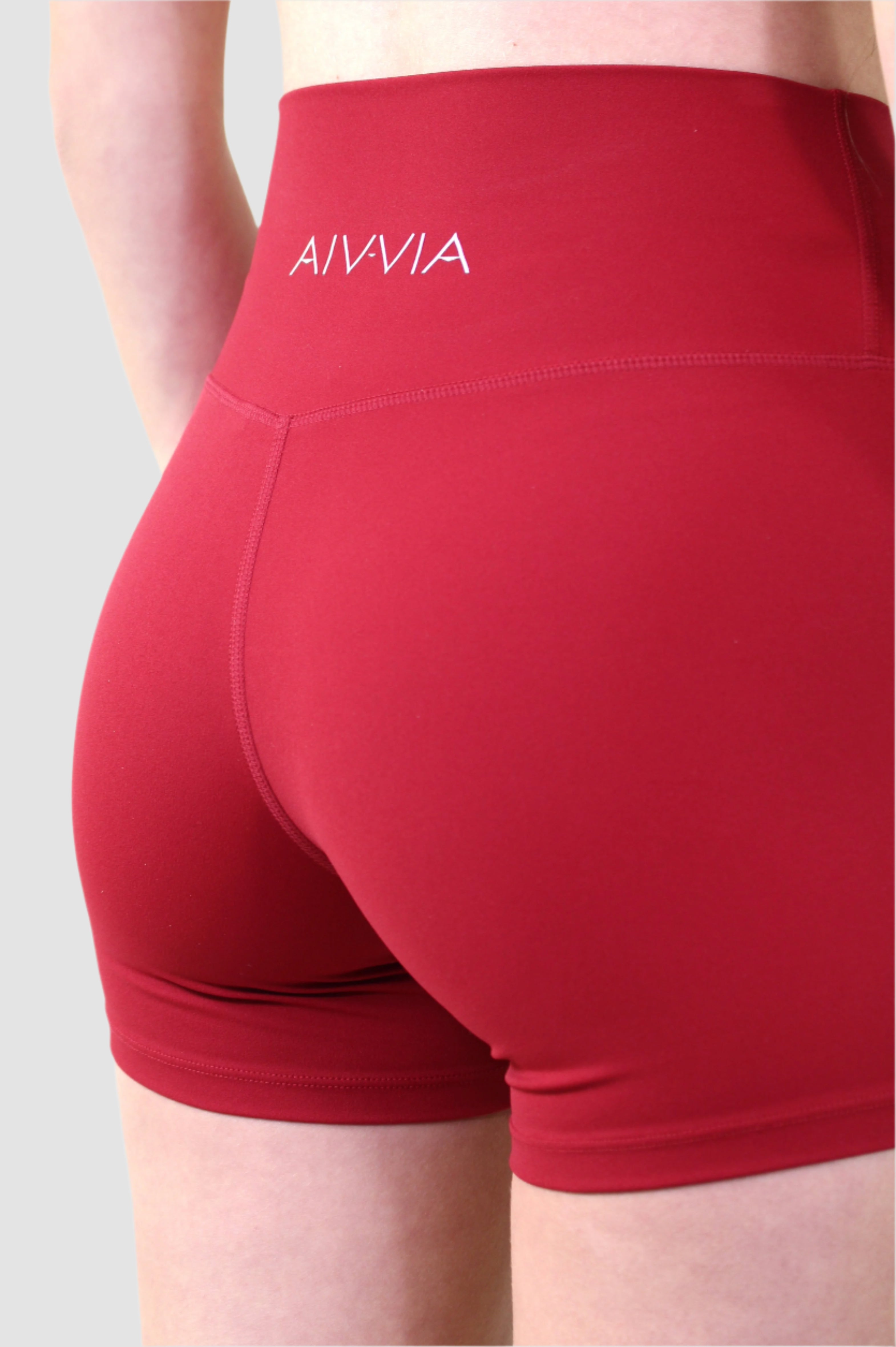 Back close-up of red Aivvia Athletics shorts featuring contour seams and minimal logo design.