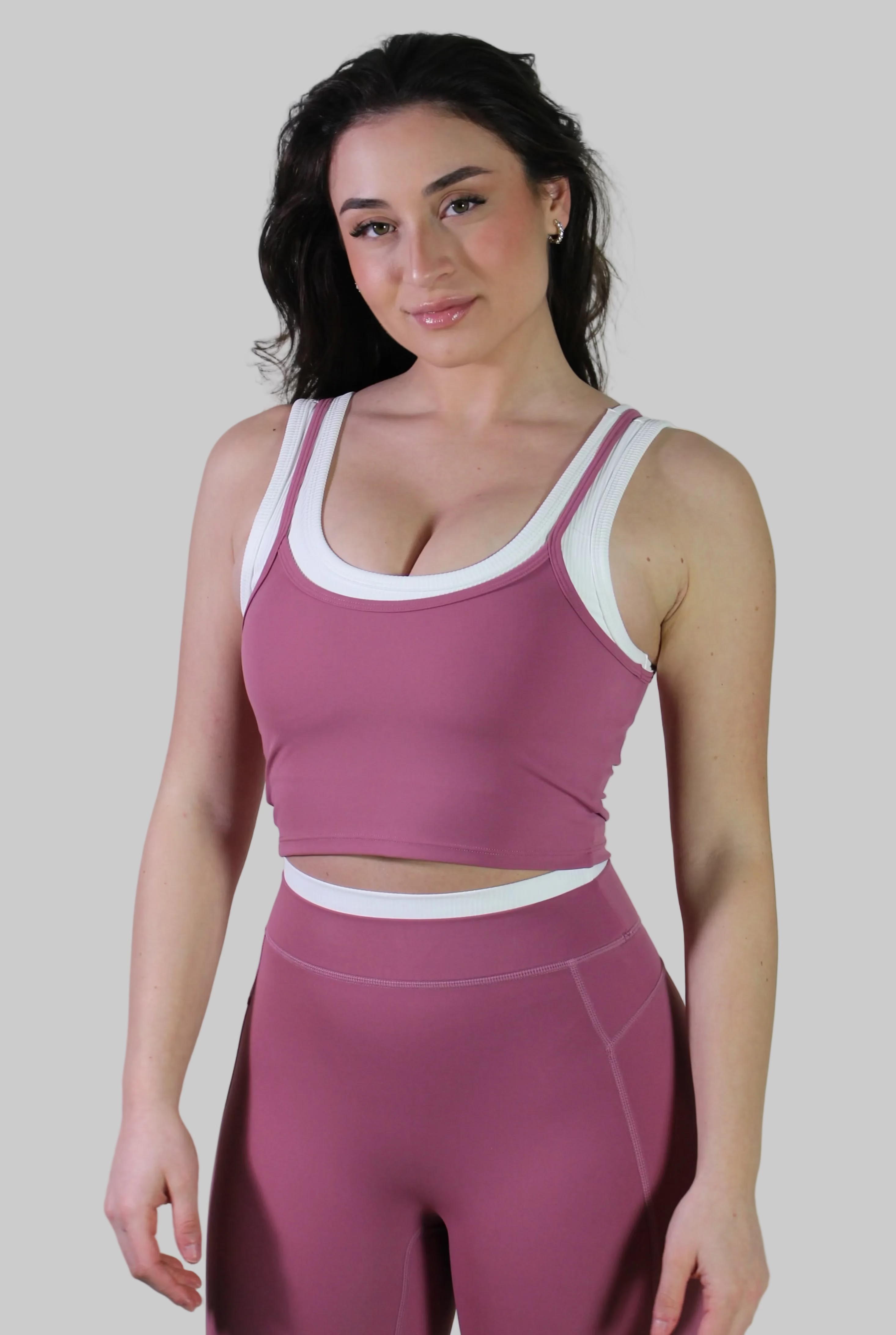 Woman wearing Aivvia Athletics rose pink cropped workout tank and high-waisted leggings gym outfit, stylish women's activewear set for fitness training and workouts.
