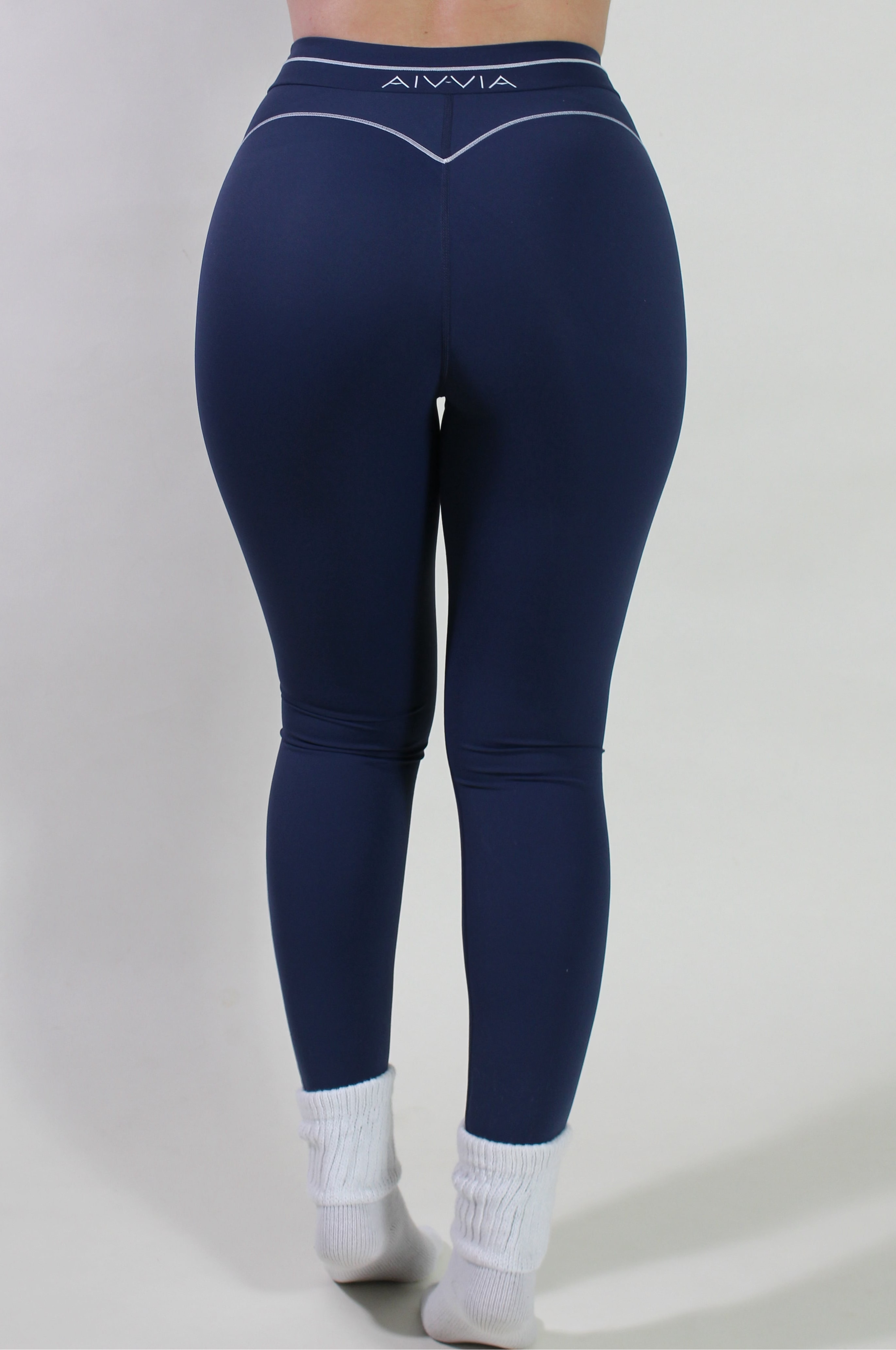 Back view of Midnight Navy Sculpt Leggings showing V-shaped glute-contouring seams and signature waistband logo, ideal for yoga, pilates, and gym training.