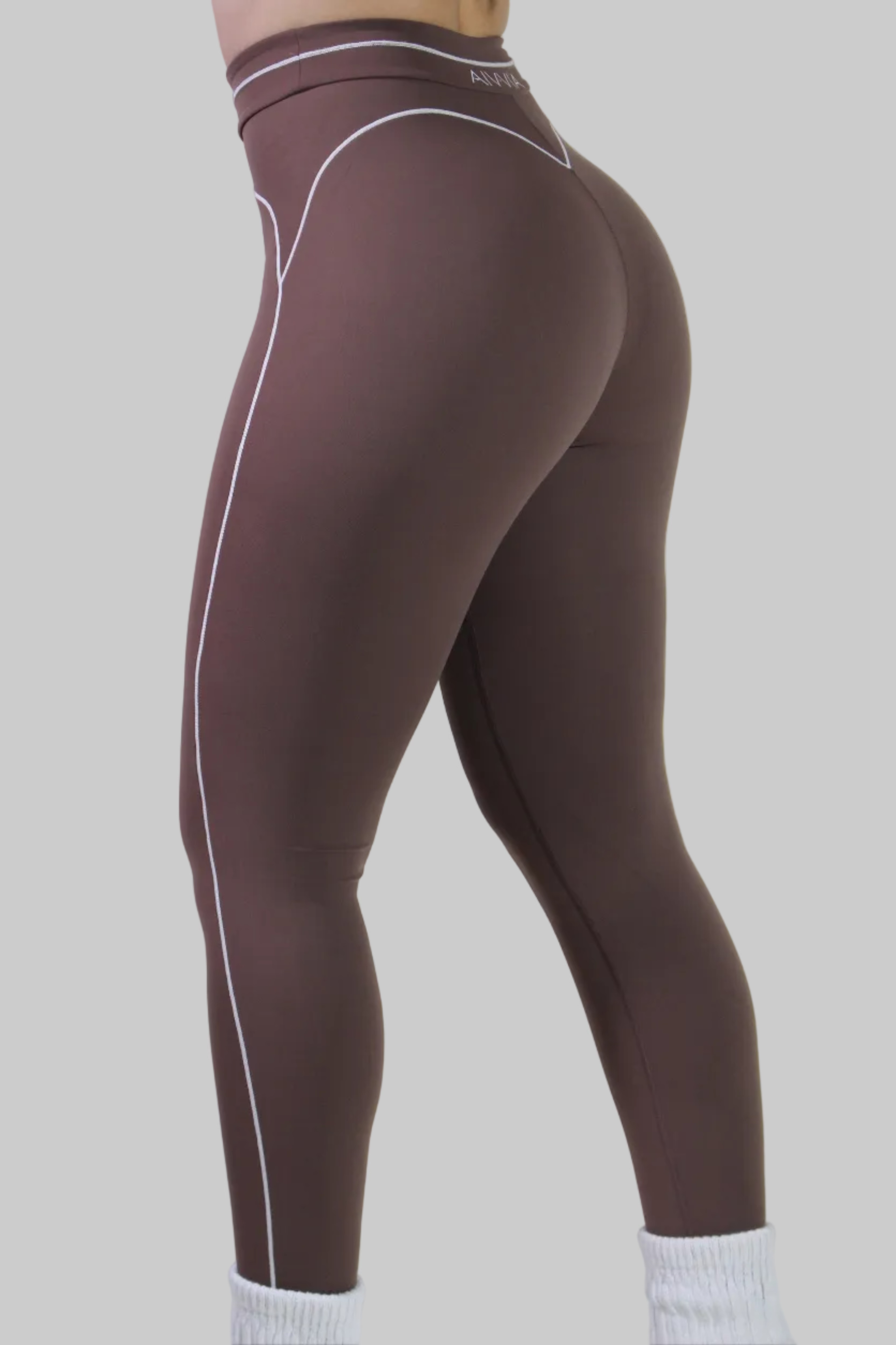 Side view of a woman wearing espresso brown sculpt leggings with high-waisted fit and smooth performance fabric, ideal for gym, pilates, and active workouts.