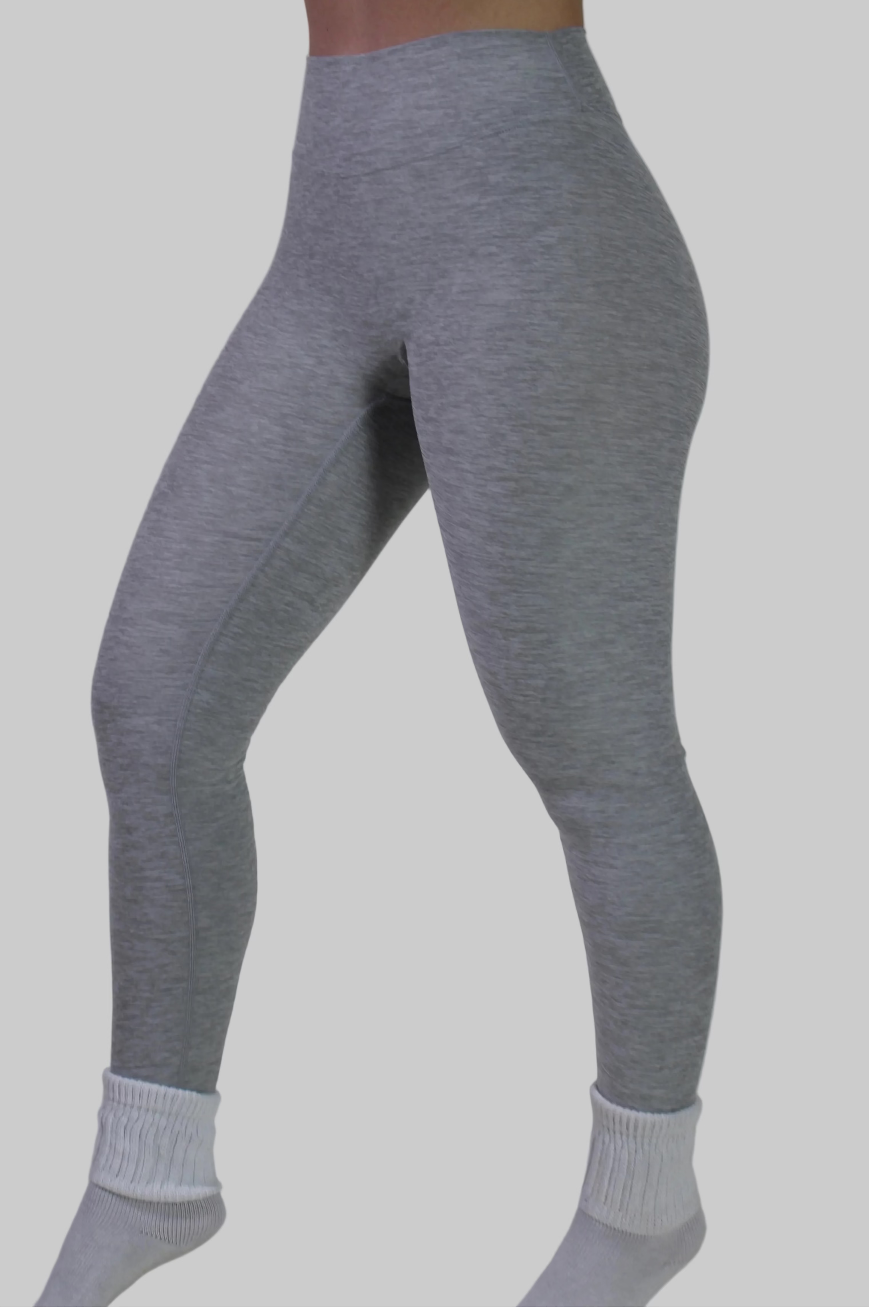Woman wearing Aivvia Athletics light gray high-waisted leggings with matching sports bra for gym and workouts.
