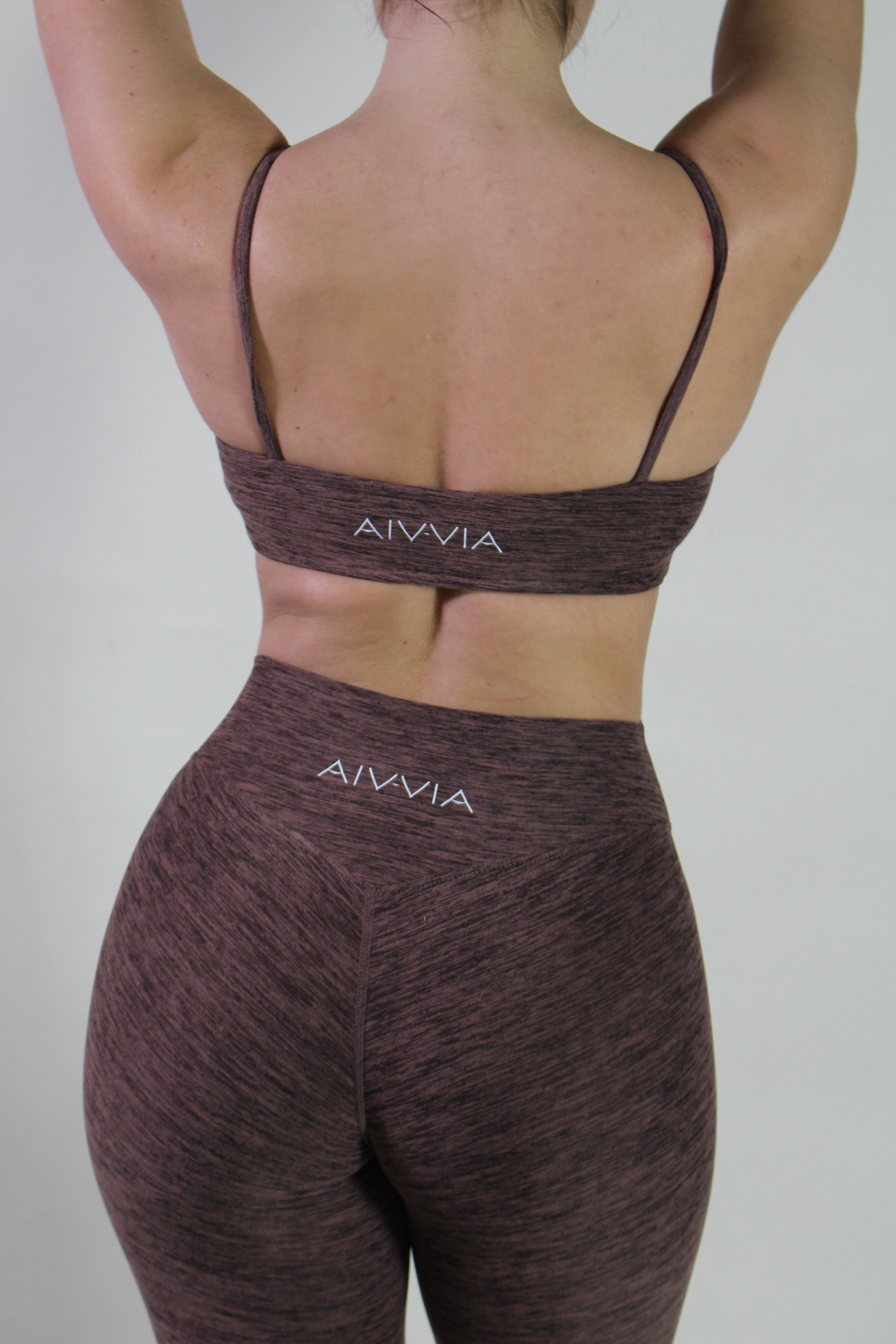 Back view of the Aivvia Athletics Marl Espresso square neck sports top, featuring a straight-cut back and signature logo on the center underband for stylish and supportive women’s gym activewear.