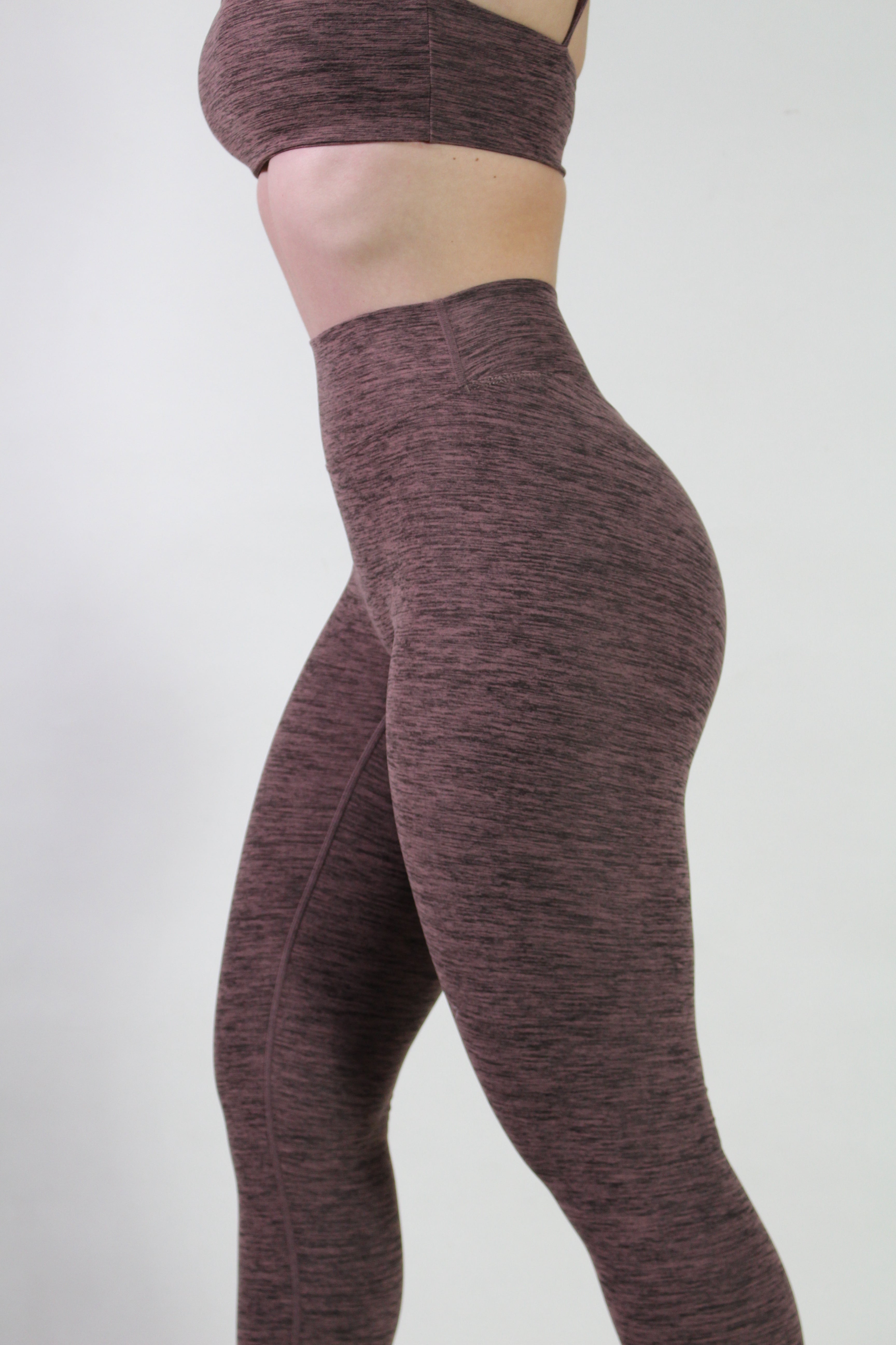 Side view of the textured brown leggings demonstrating the high-waisted fit and the smooth, non-see-through fabric on a model.