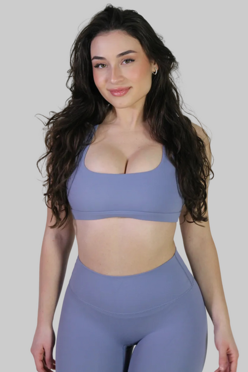 Front view of the Aivvia Athletics purple-blue bra showcasing the sharp square neckline and longline silhouette.