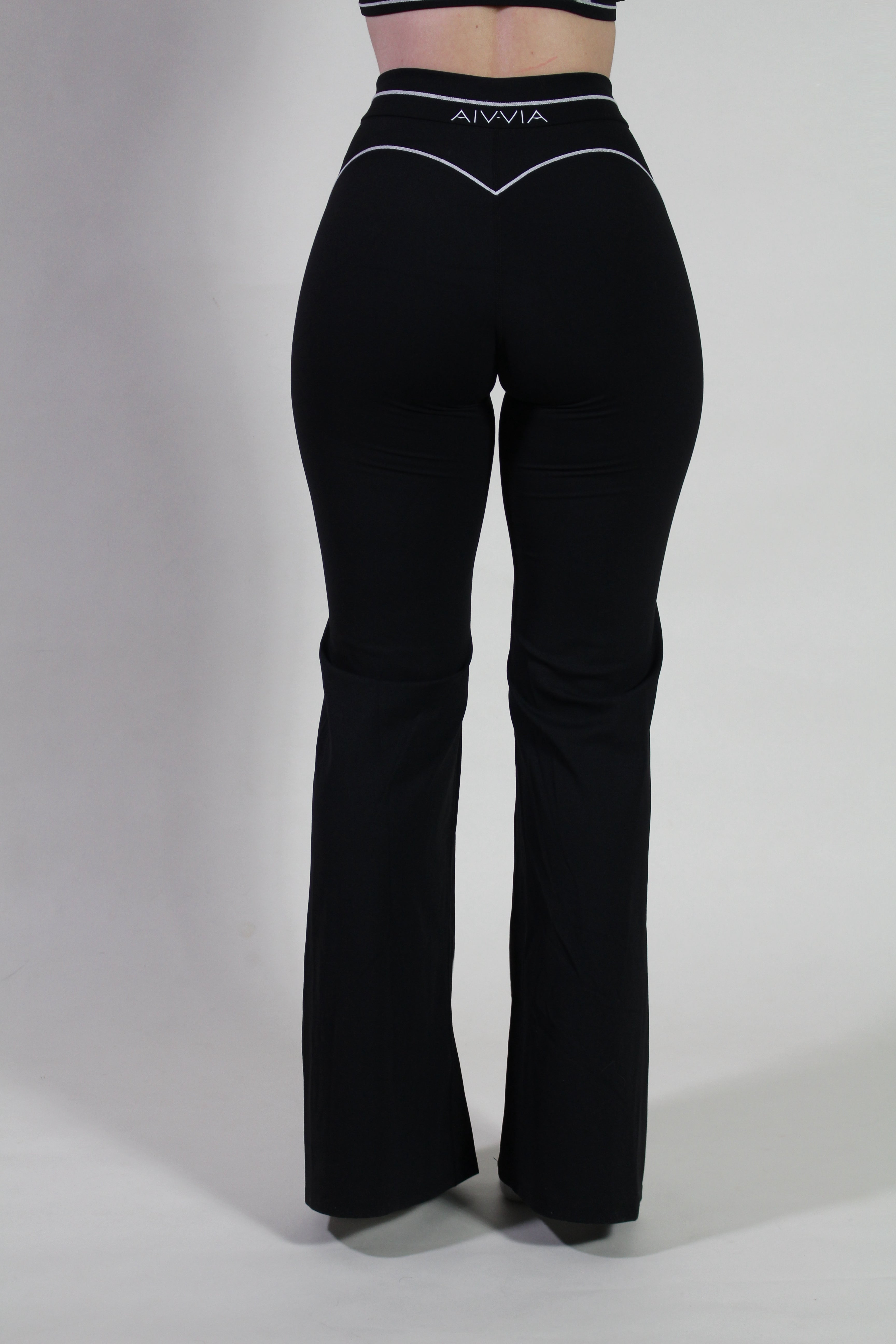 Back view of Aivvia Athletics black yoga pants showing high-rise waistband and contoured fit, perfect for gym, yoga, and pilates activities.