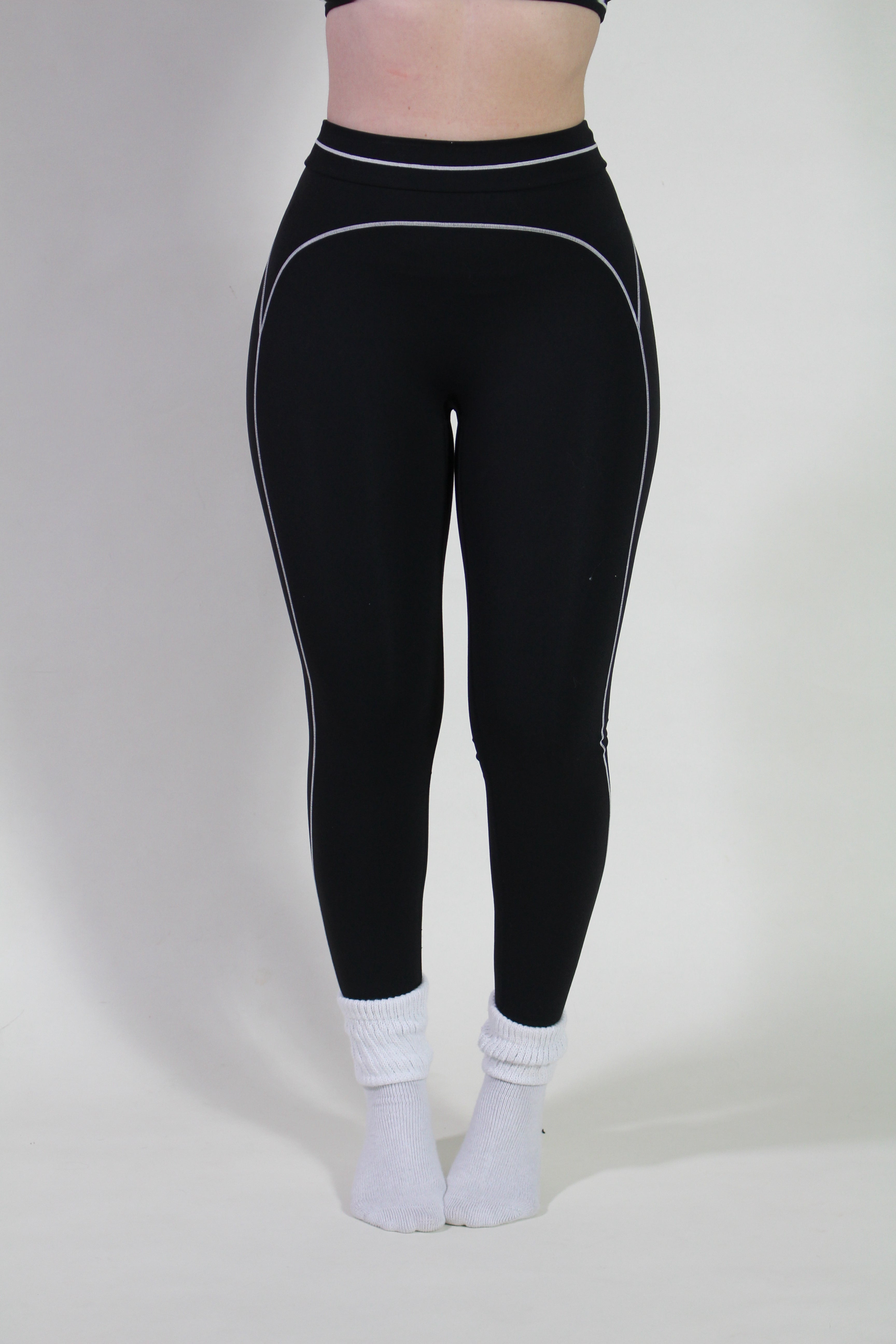 Front view of a woman wearing Onyx Black Sculpt leggings, featuring high-waisted fit, ideal for gym, pilates, and active workouts.