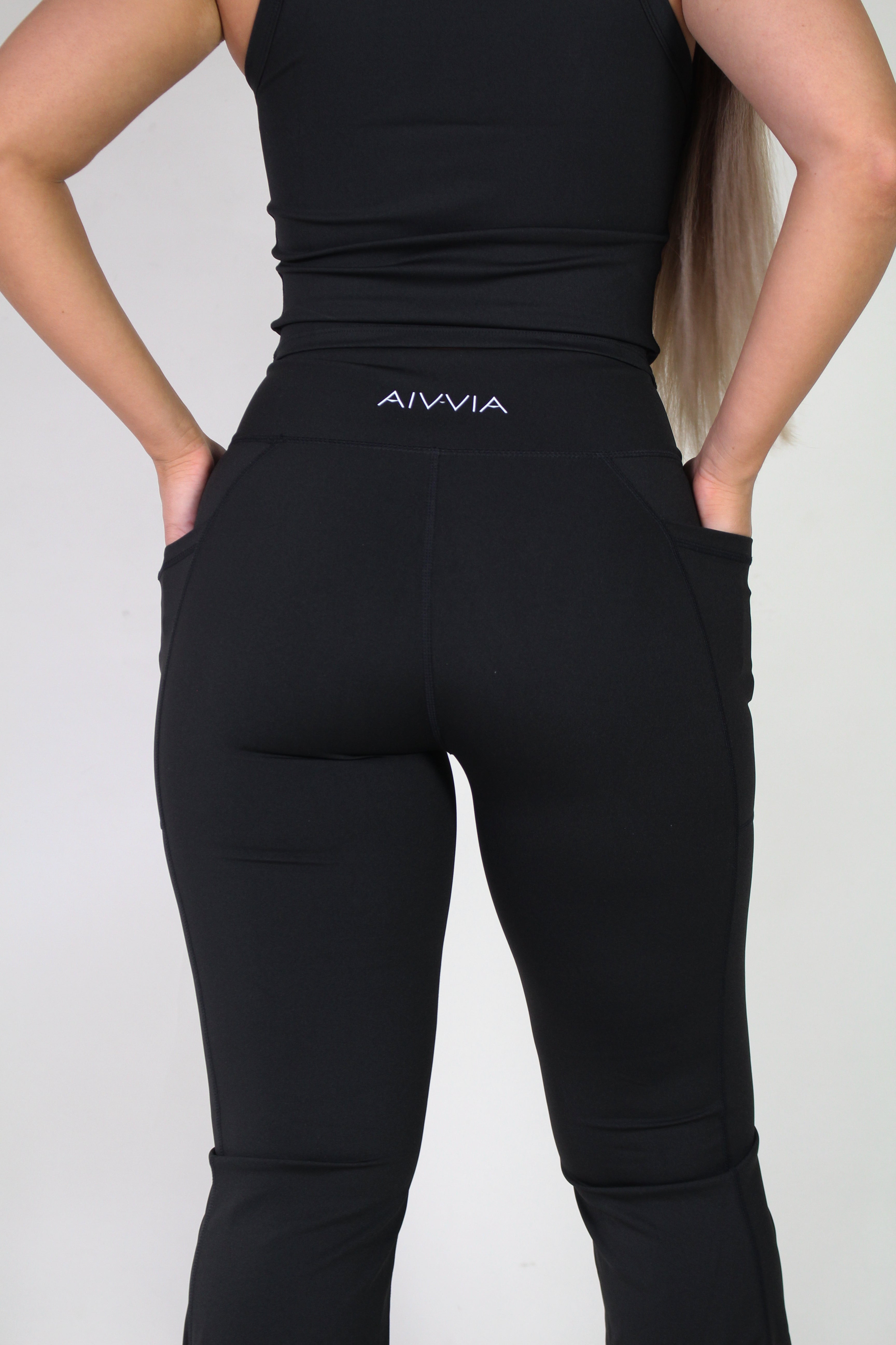 Rear view of Aivvia Athletics black sculpt pants, displaying subtle logo detail, secure waistband, and functional side pockets.