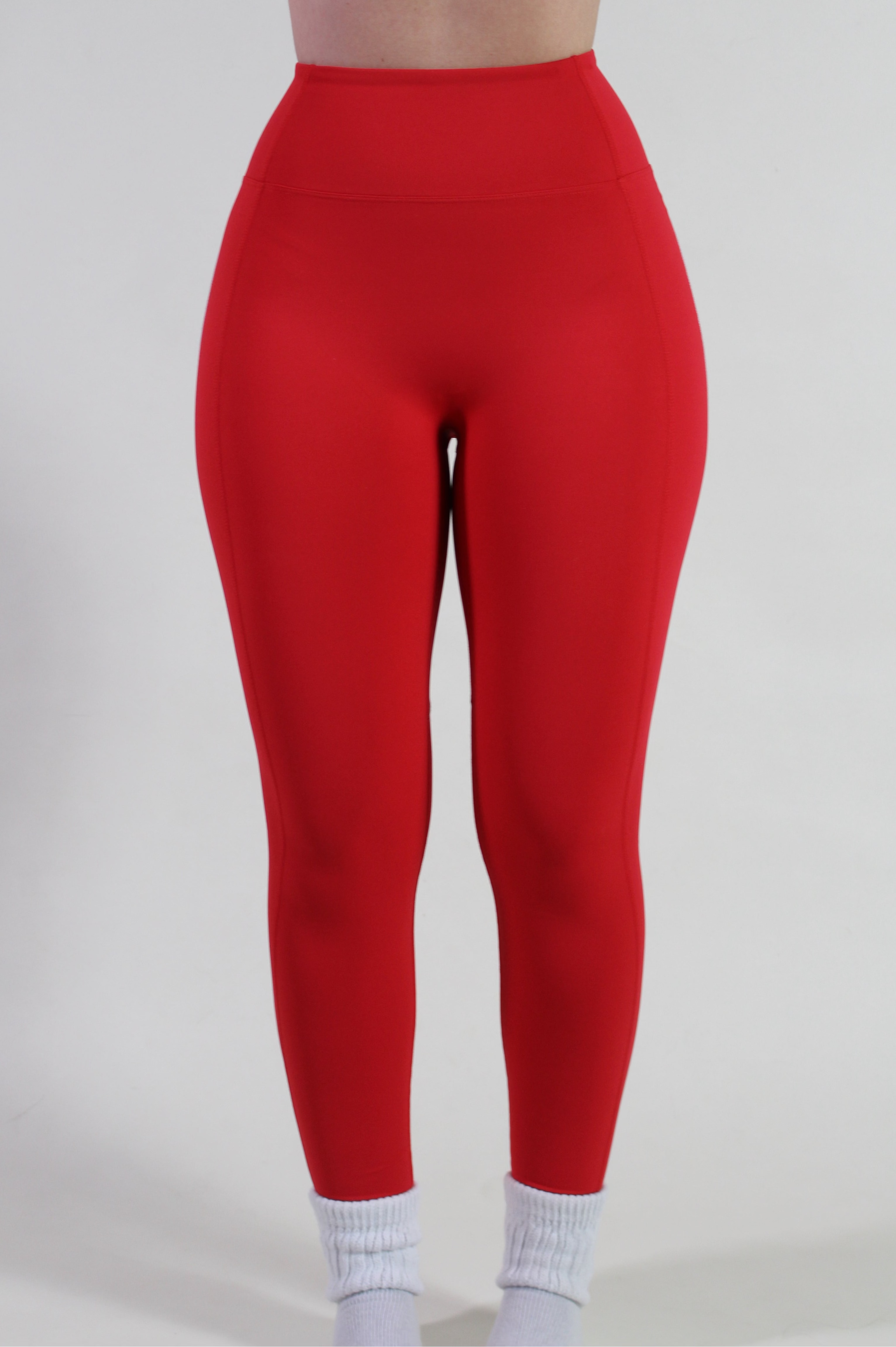 Front view of Aivvia Athletics red high-waisted leggings with smooth front panel and secure waistband for gym and yoga.