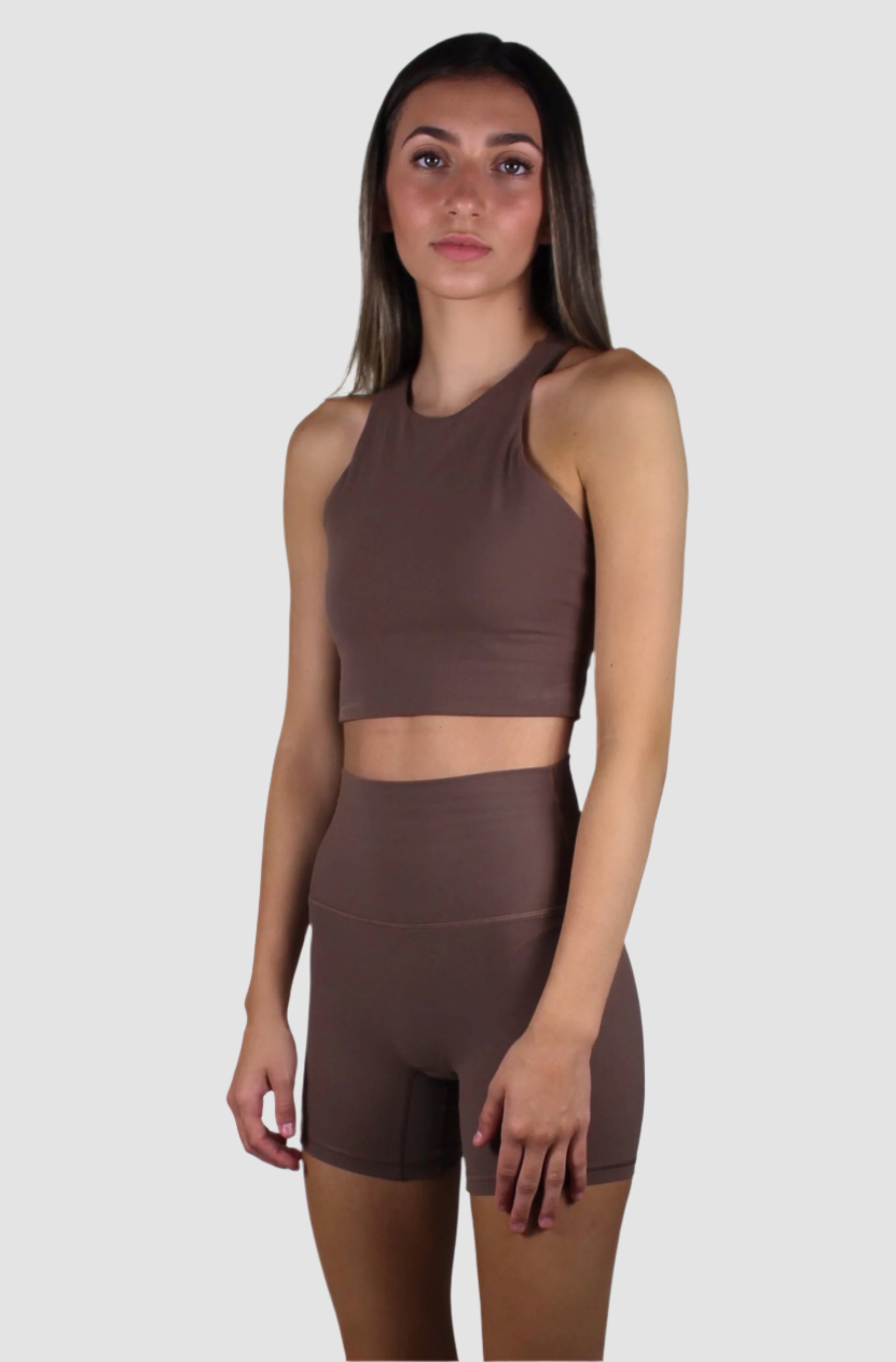 Front view of a chocolate brown activewear set featuring a high-neck cropped tank top and matching high-waisted biker shorts.