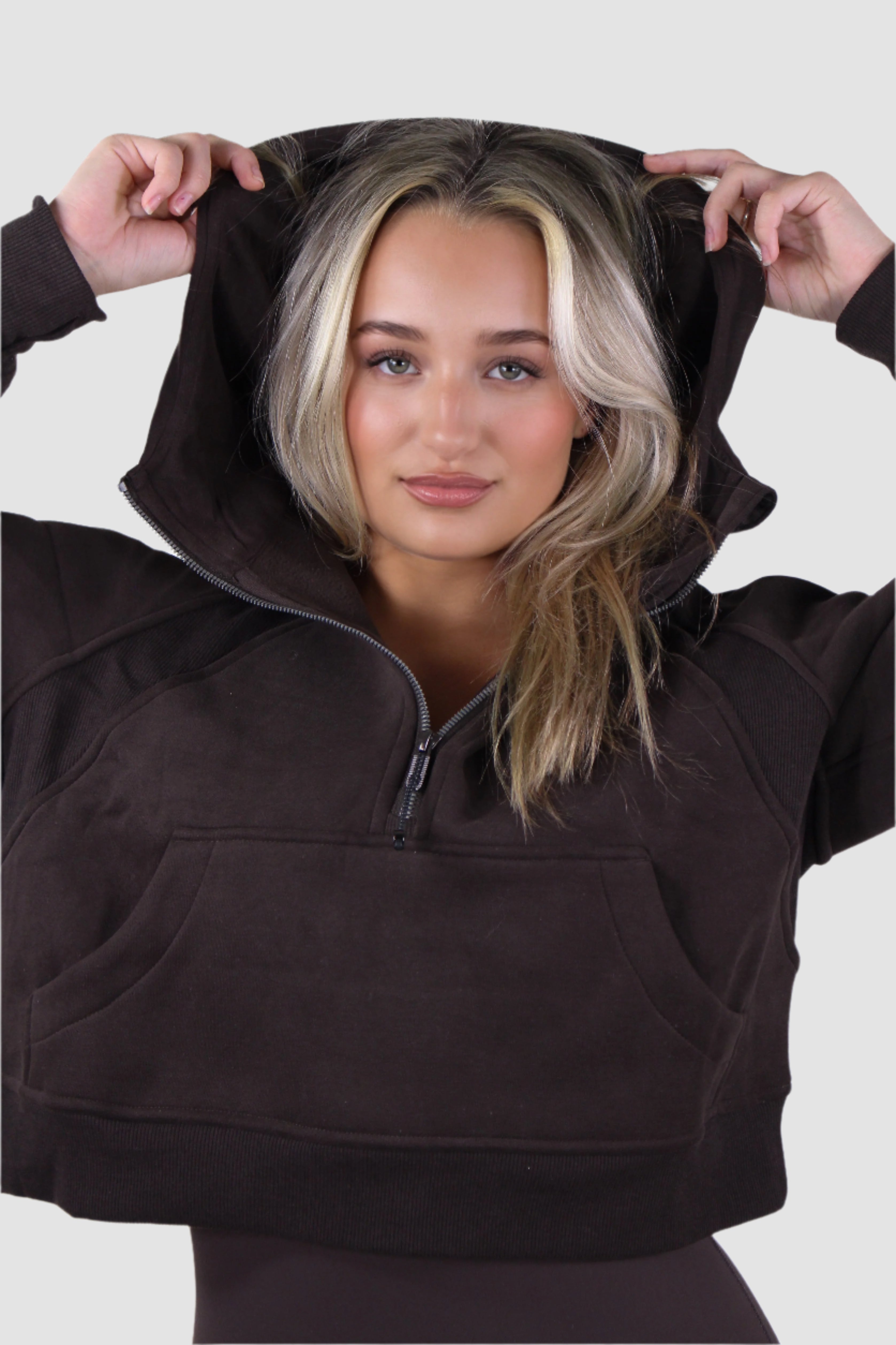 Aivvia Athletics women's cropped quarter zip hoodie in deep brown, hood up, sporty-chic activewear look.