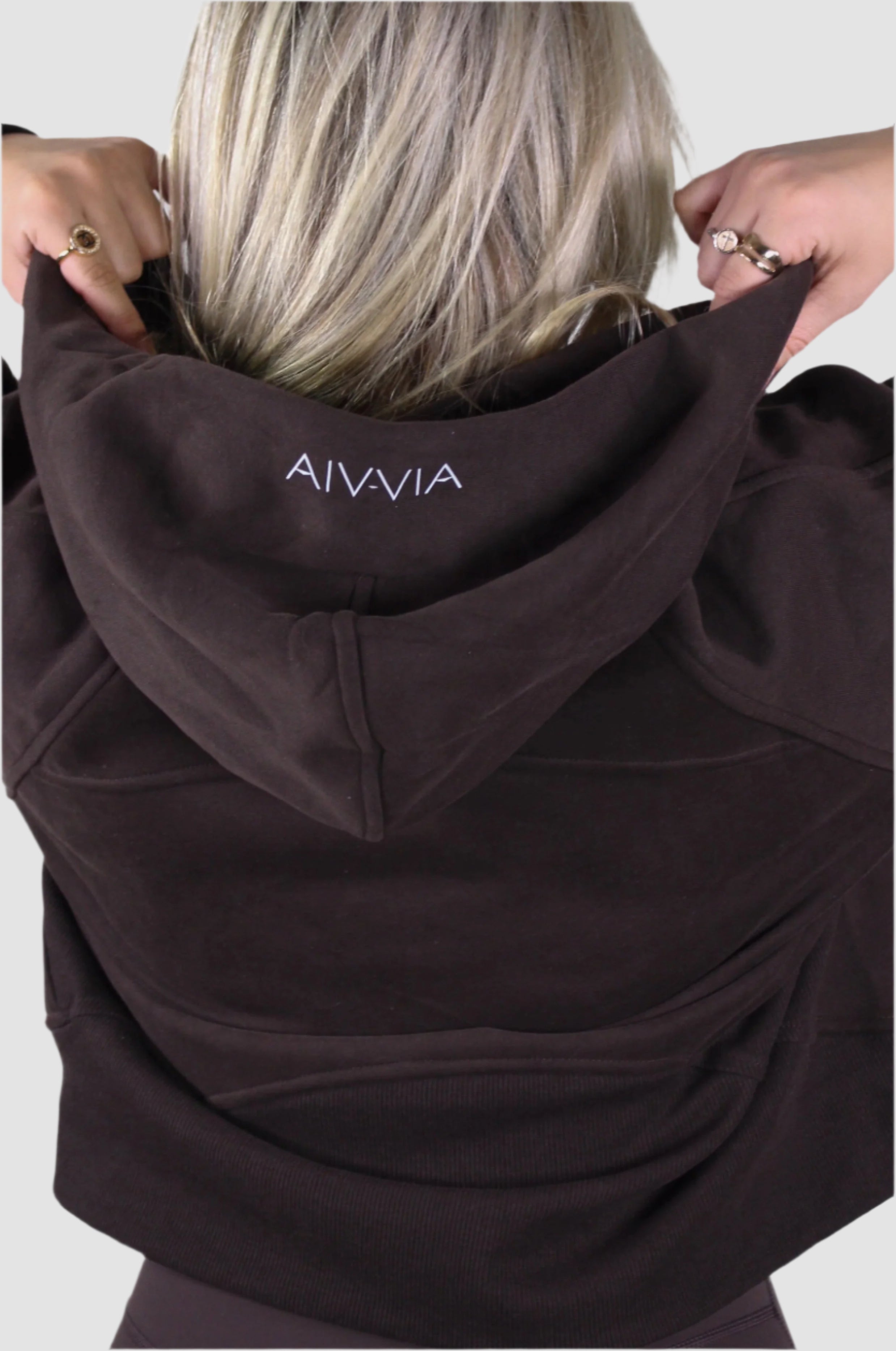 Back of Aivvia Athletics cropped quarter zip hoodie, deep brown, logo on hood, premium women's athletic wear.