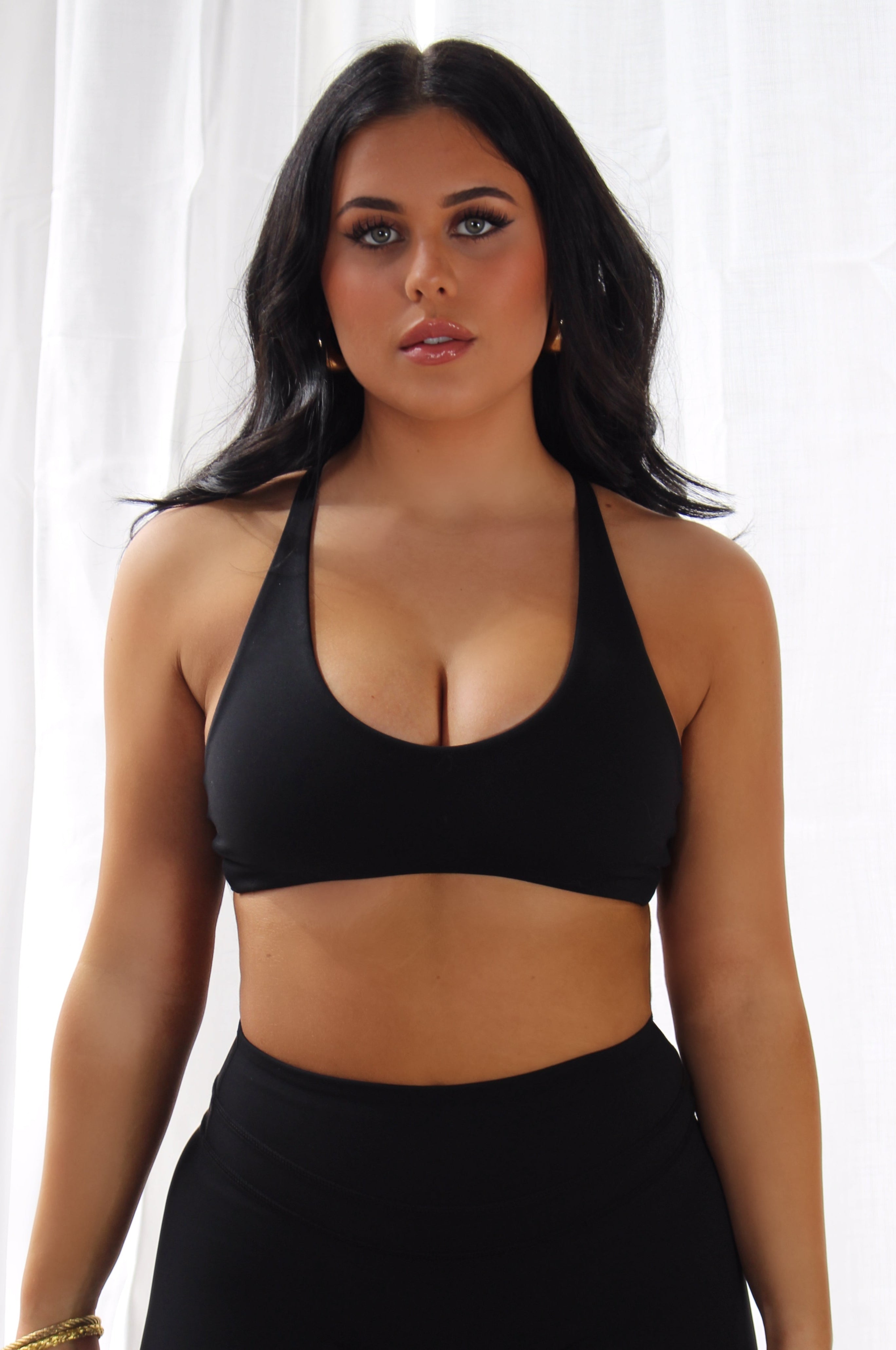 Woman in black Aivvia Athletics sports bra; deep scoop neckline and supportive fit for workouts.
