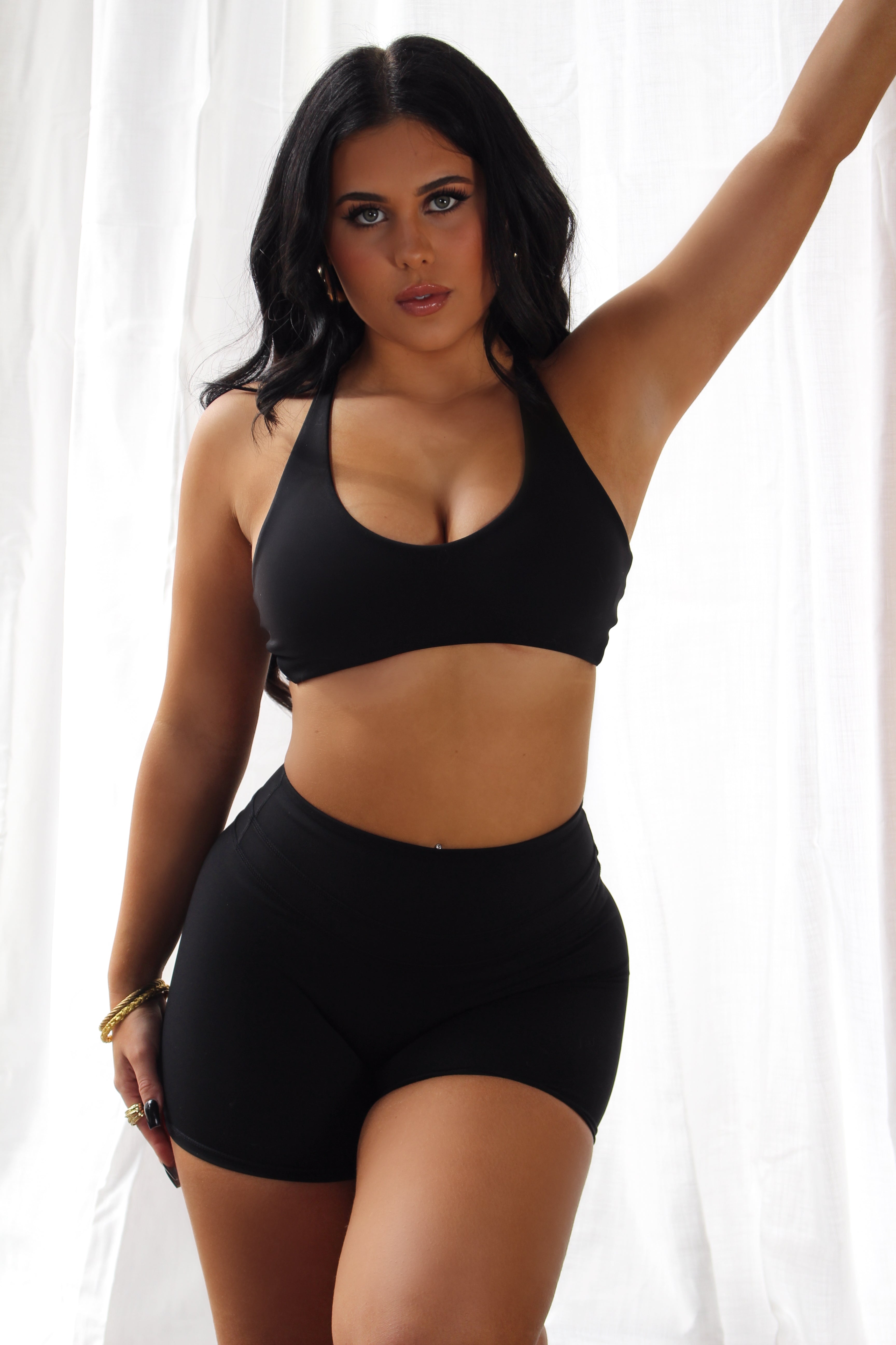 Minimalist black sports bra by Aivvia Athletics; cropped, body-hugging activewear for women.