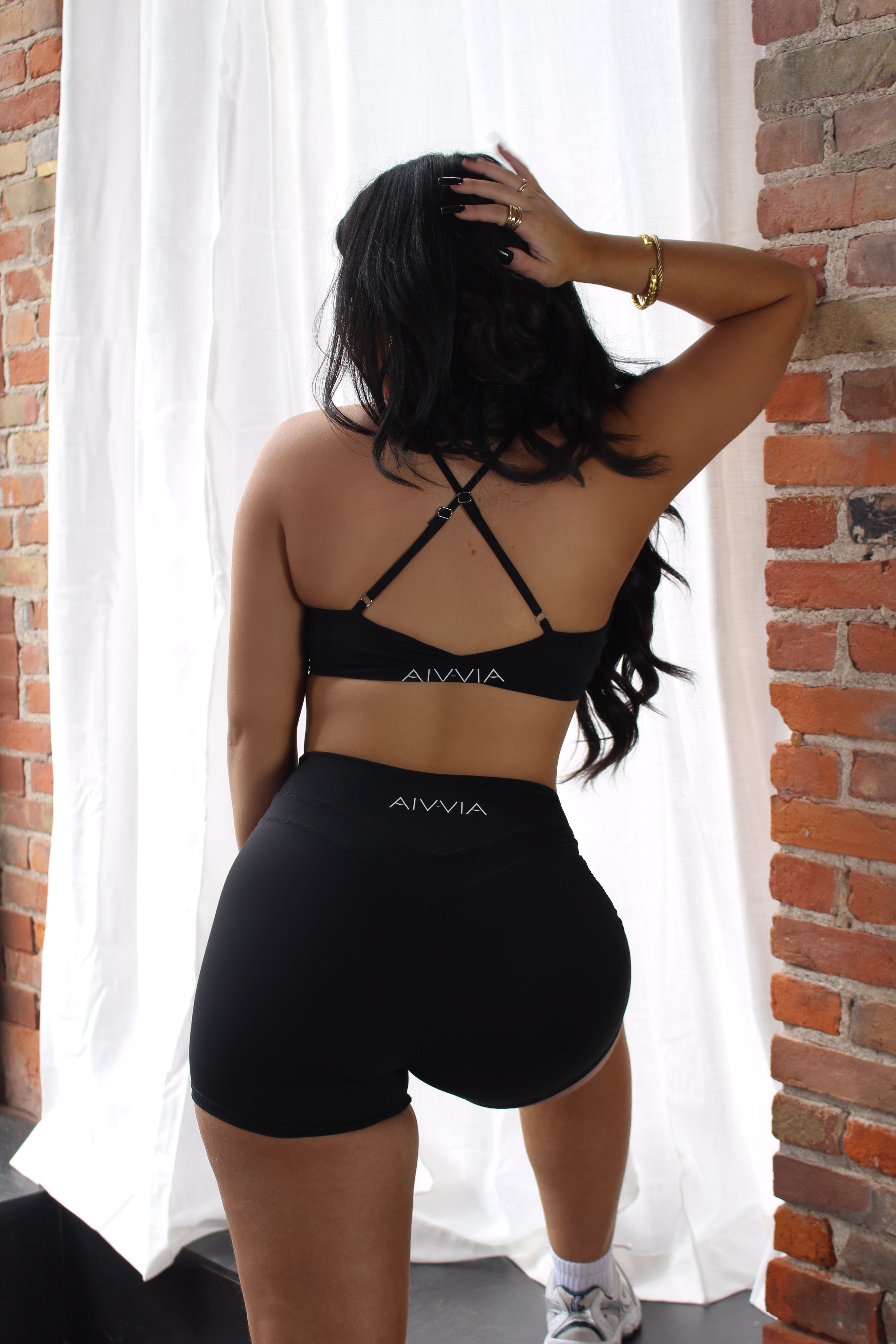 Black Aivvia Athletics sports bra with open back and cross straps for flexibility and style.