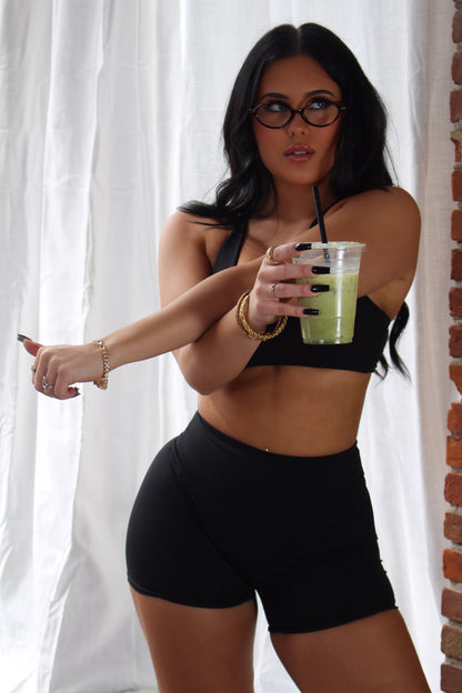 Woman in black Aivvia Athletics high-waisted shorts; sleek, supportive fit for training, yoga, and everyday comfort.