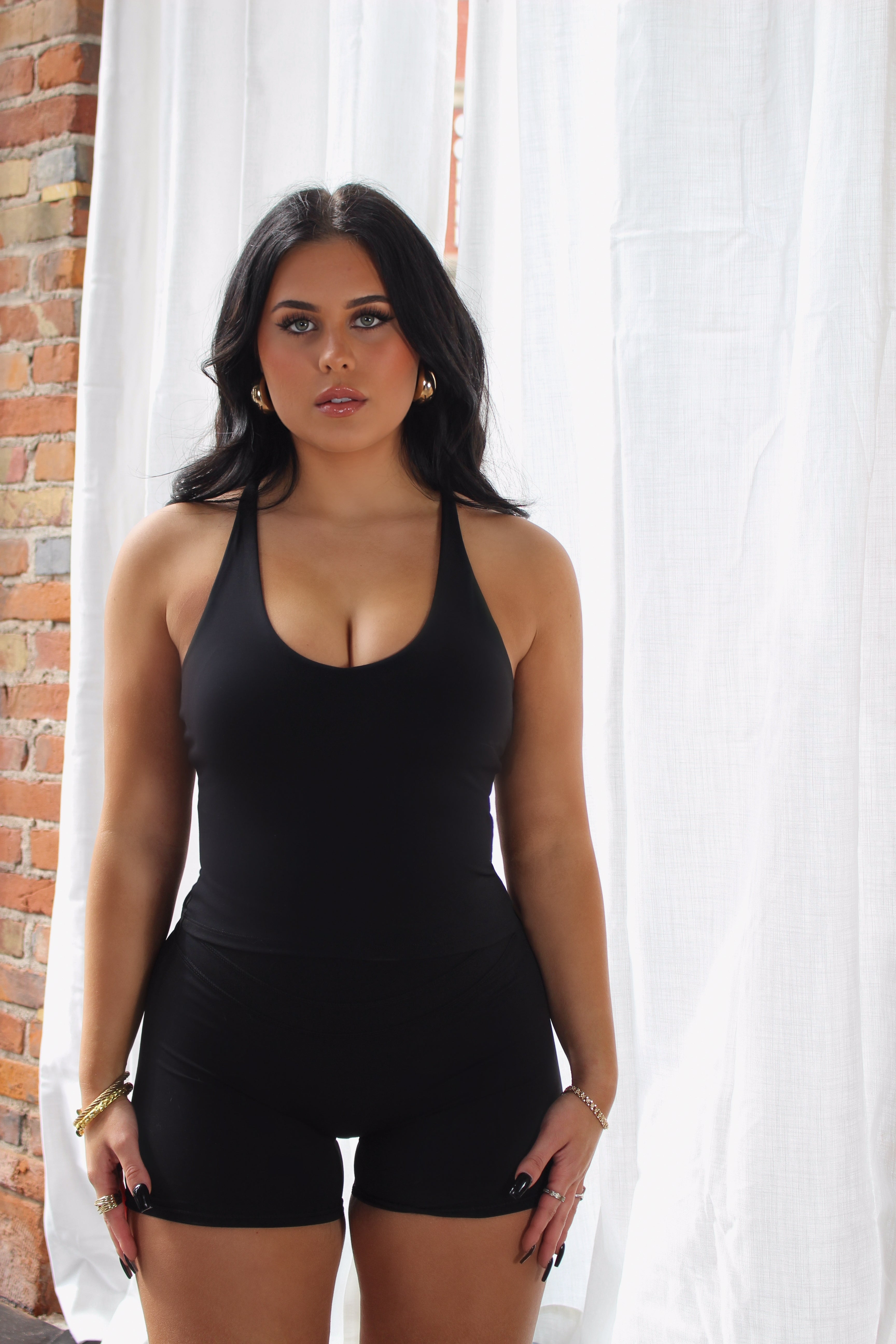 Woman in black Aivvia Athletics tank top; performance-ready design ideal for yoga, running, and training.