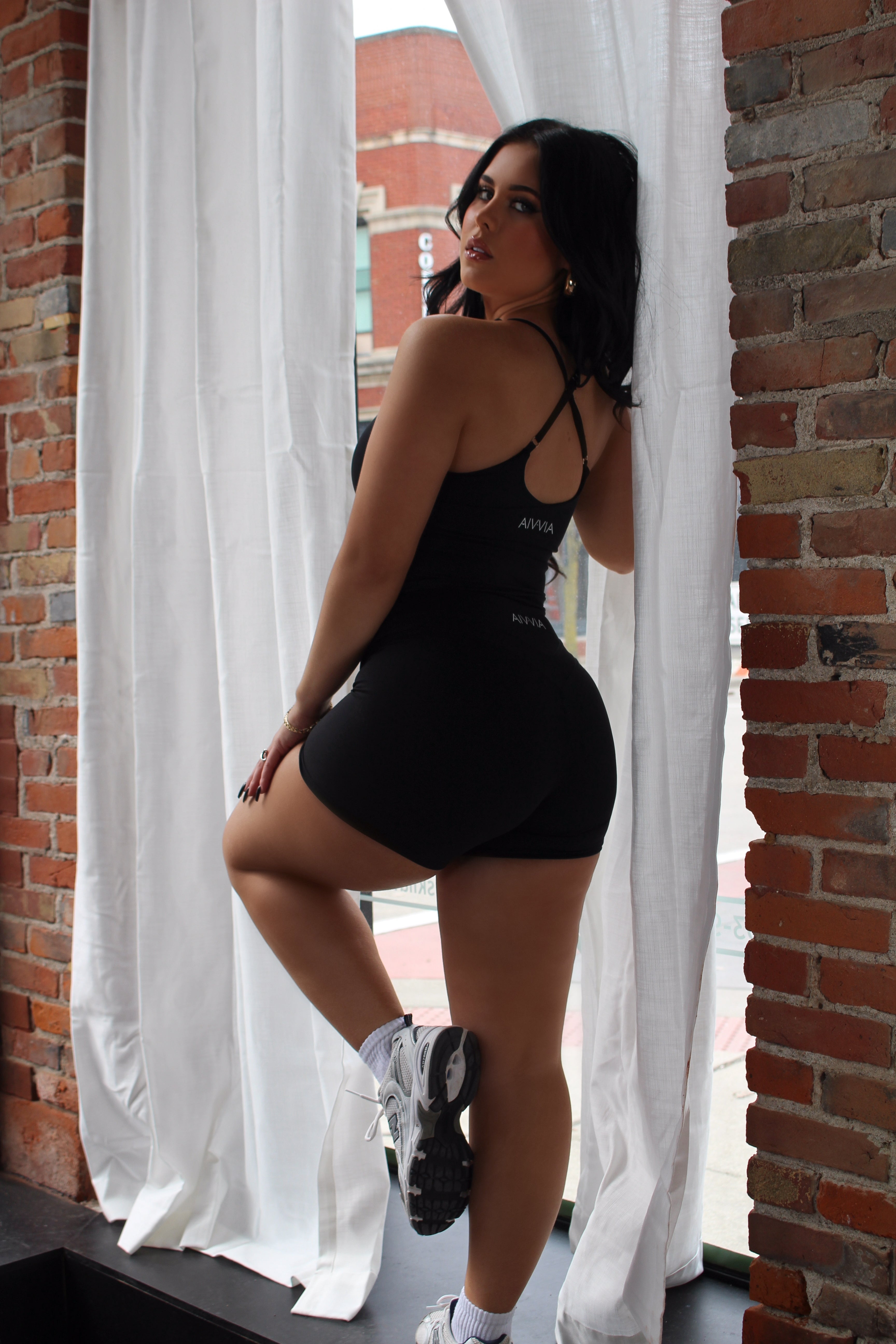 Side-back view of black Aivvia Athletics tank top; flattering fit with racerback straps for comfort and mobility.