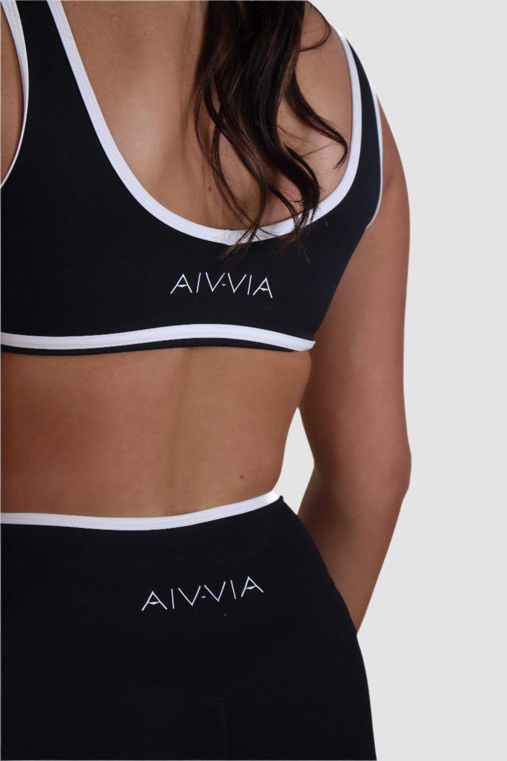 Close-up view of black Aivvia Athletics shorts, eco-friendly fabric with body-hugging fit and white contrast trim.