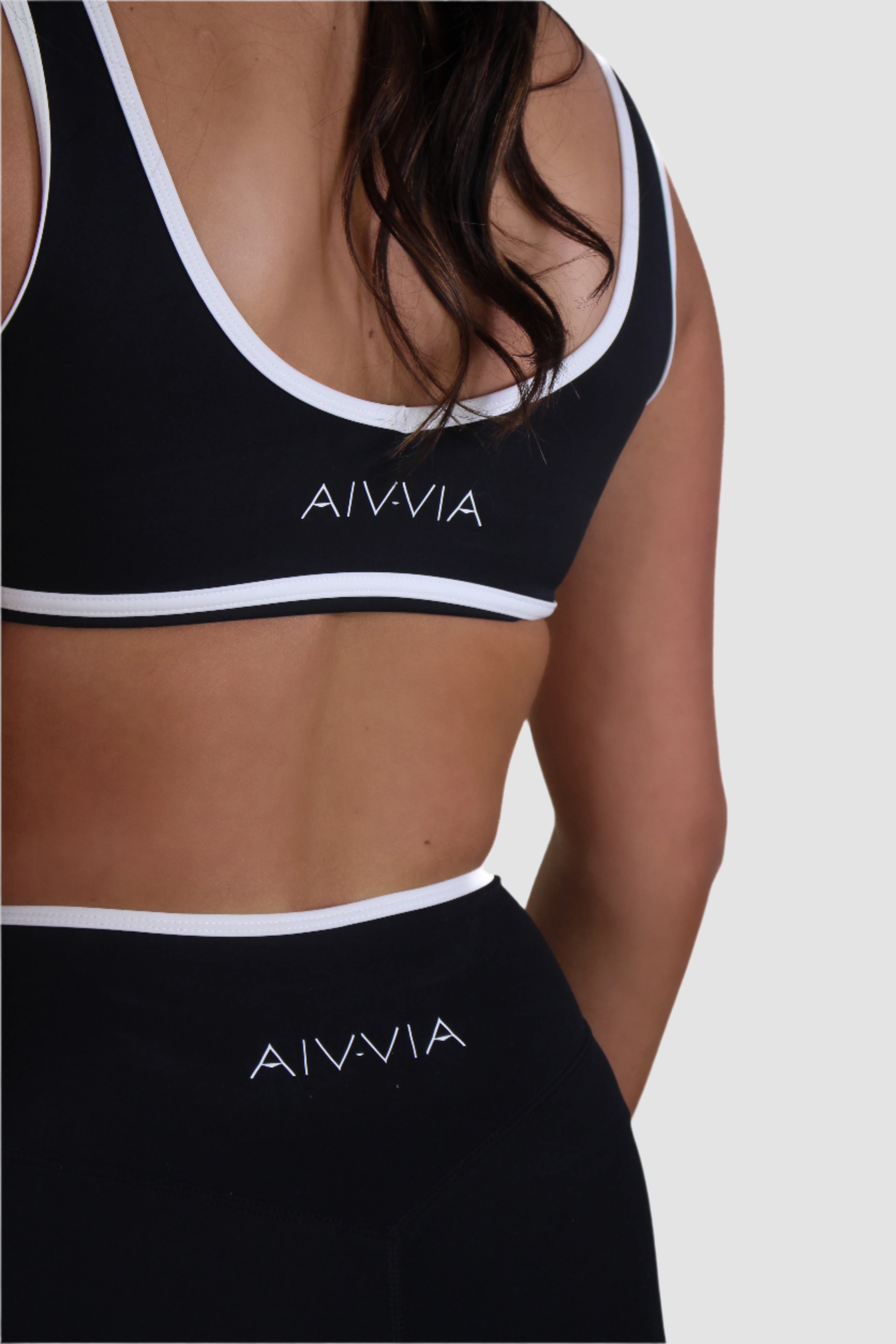 Close-up view of black Aivvia Athletics shorts, eco-friendly fabric with body-hugging fit and white contrast trim.