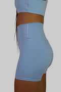Light blue athletic shorts worn by a person on a beige background