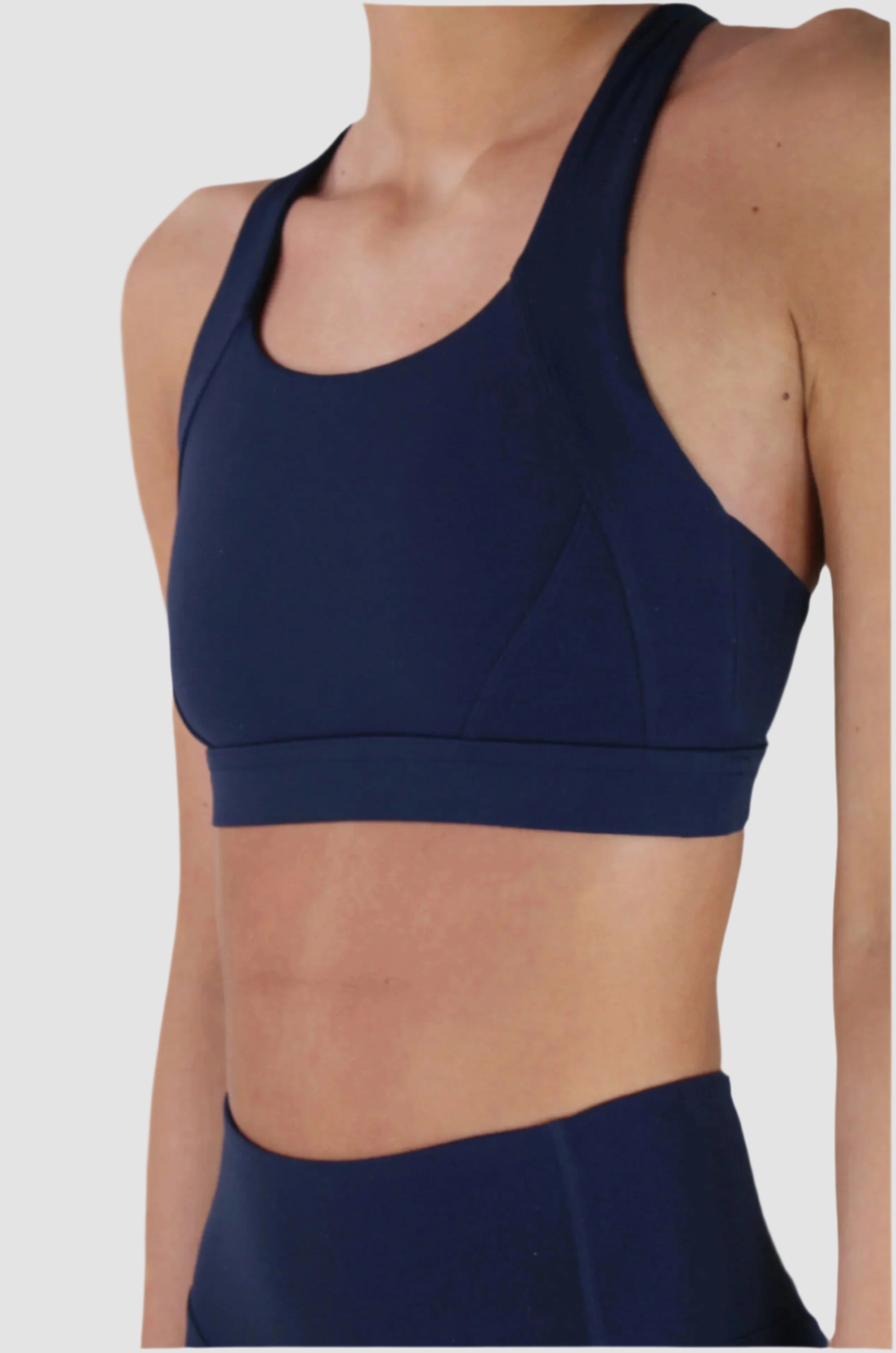 Front close-up of Aivvia Athletics navy sports bra with scoop neckline, soft stretch fabric, and supportive fit.