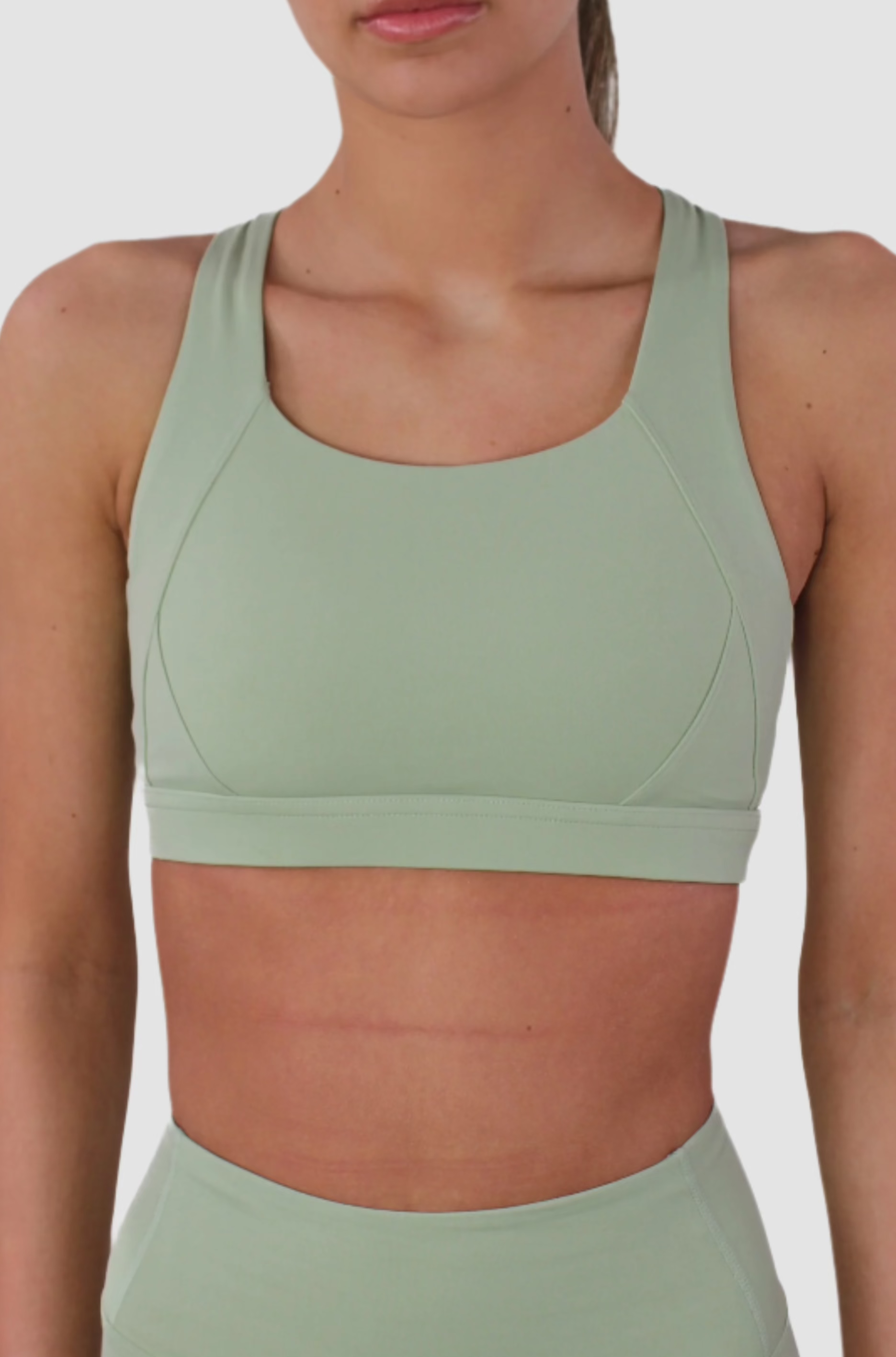 Close-up of Aivvia Athletics sage green sports bra with smooth contouring and sweat-wicking stretch fabric.