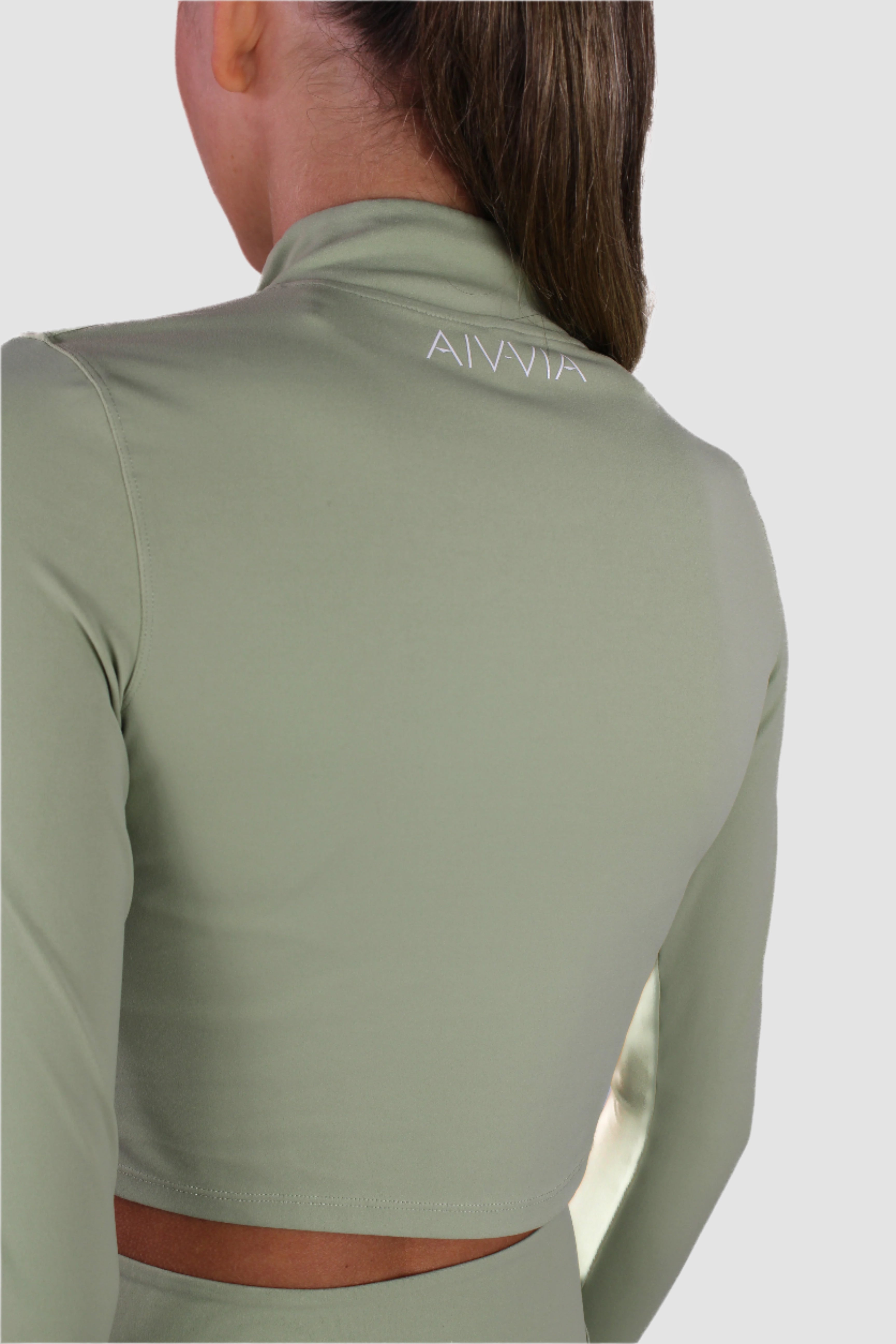 Light sage green Aivvia Athletics cropped jacket showing back contour and logo at waistband.