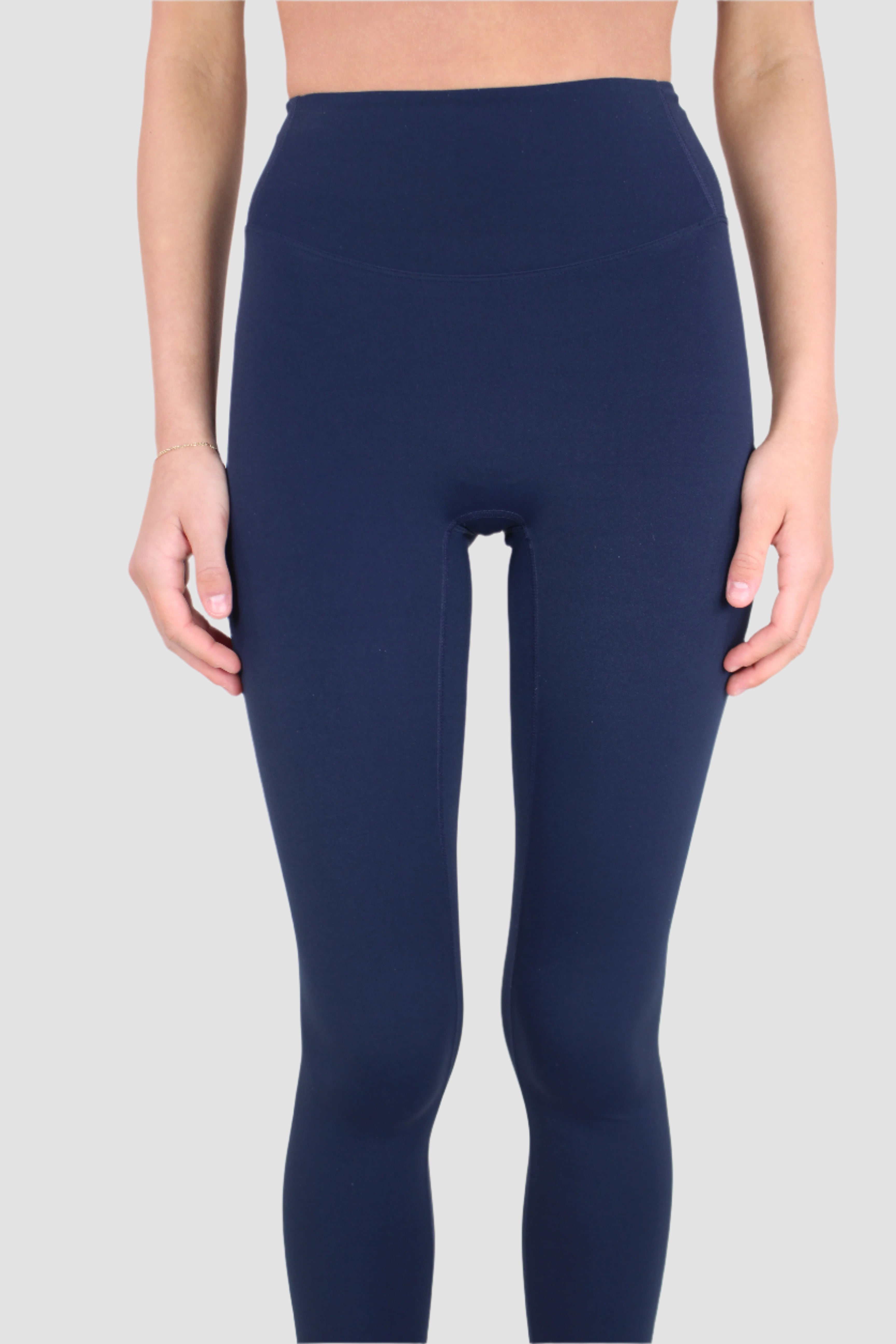 Woman wearing navy blue Aivvia Aesthetics leggings, highlighting high-waist fit and smooth stretch fabric.