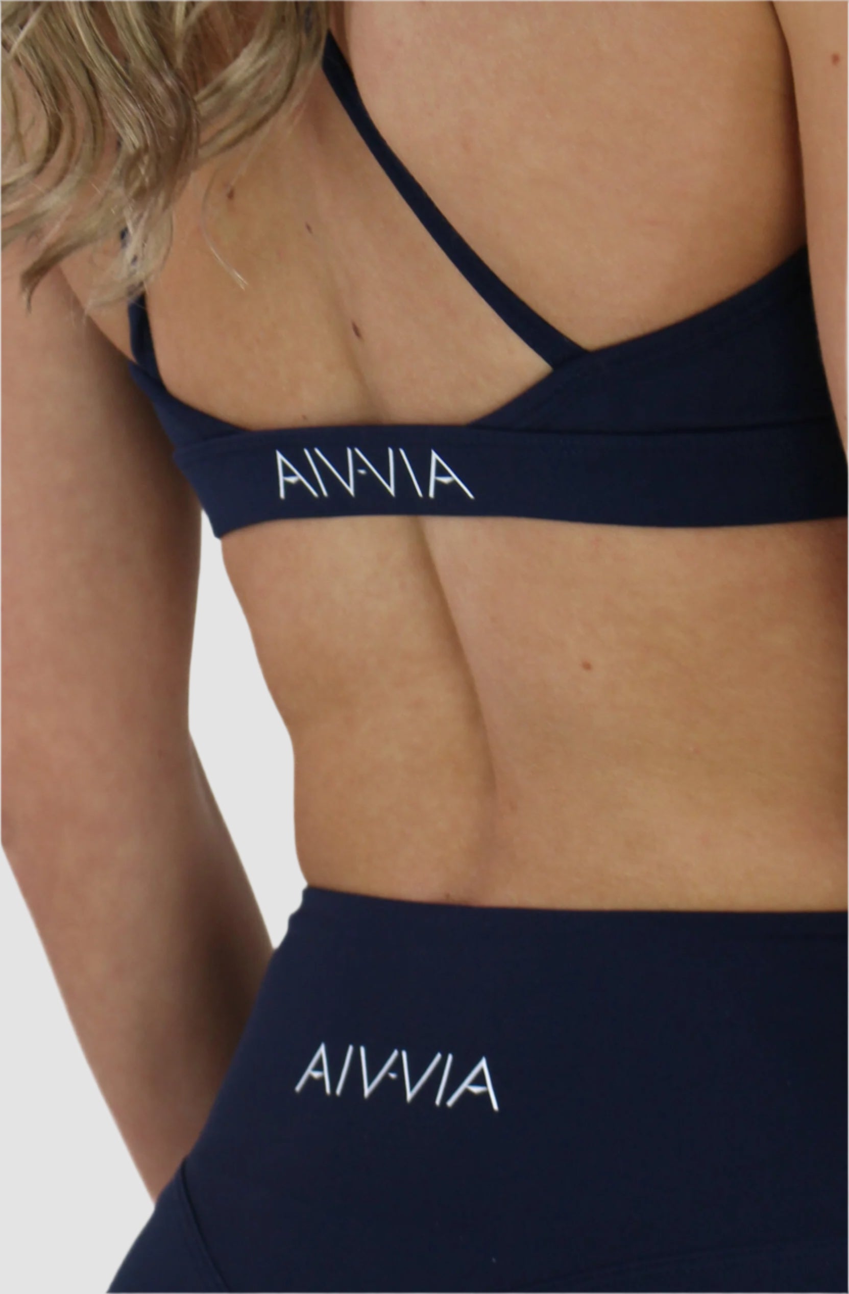 Close-up of Aivvia Athletics logo on navy sports bra – premium branded activewear designed for support, style, and performance.