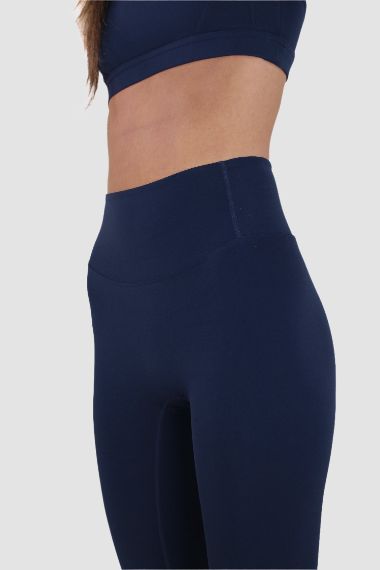 Side view of navy Aivvia Athletics leggings highlighting smooth compression fit and ankle length.