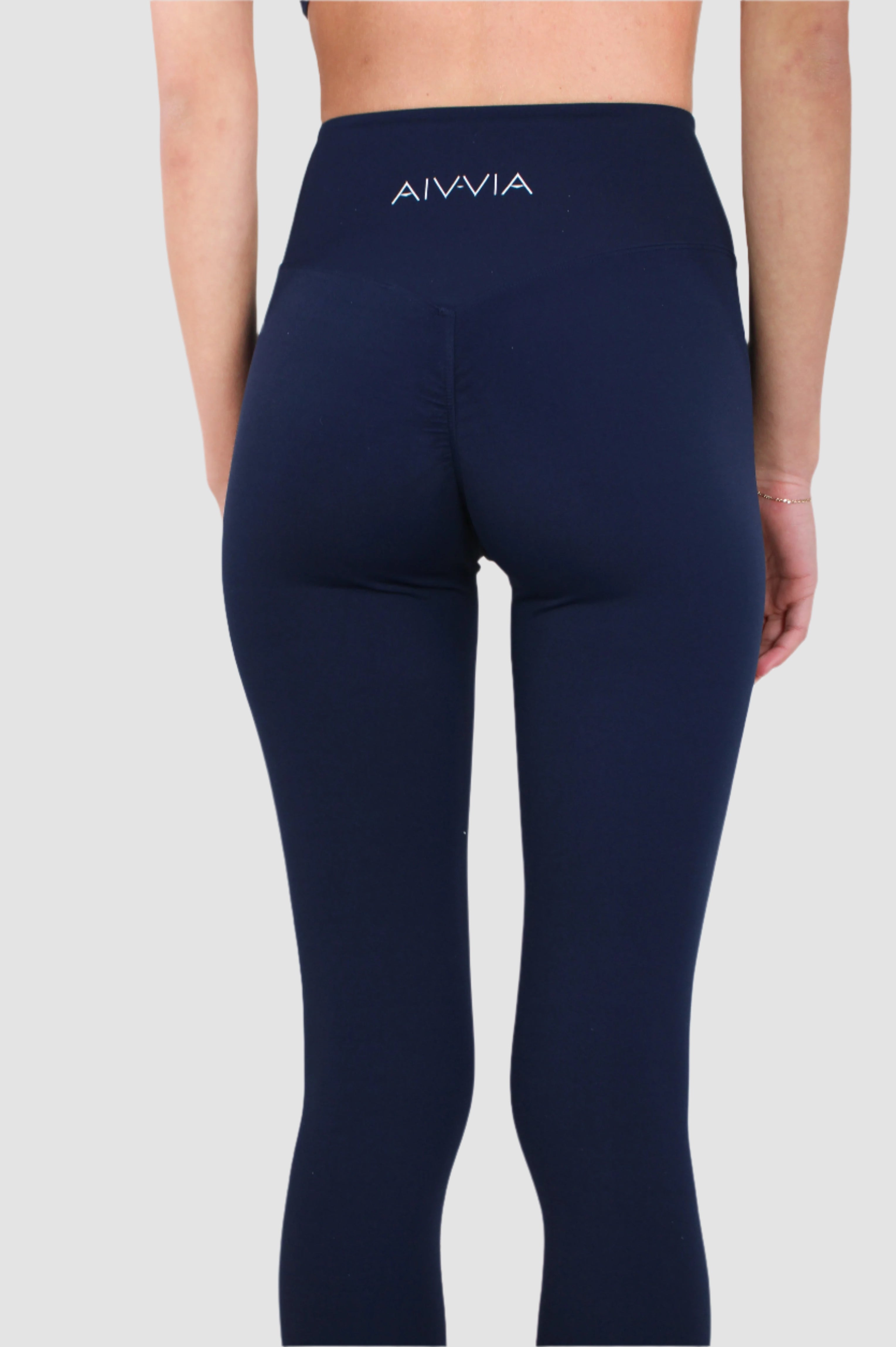Back view of navy Aivvia Athletics leggings with logo detail on waistband and flattering seam lines.

