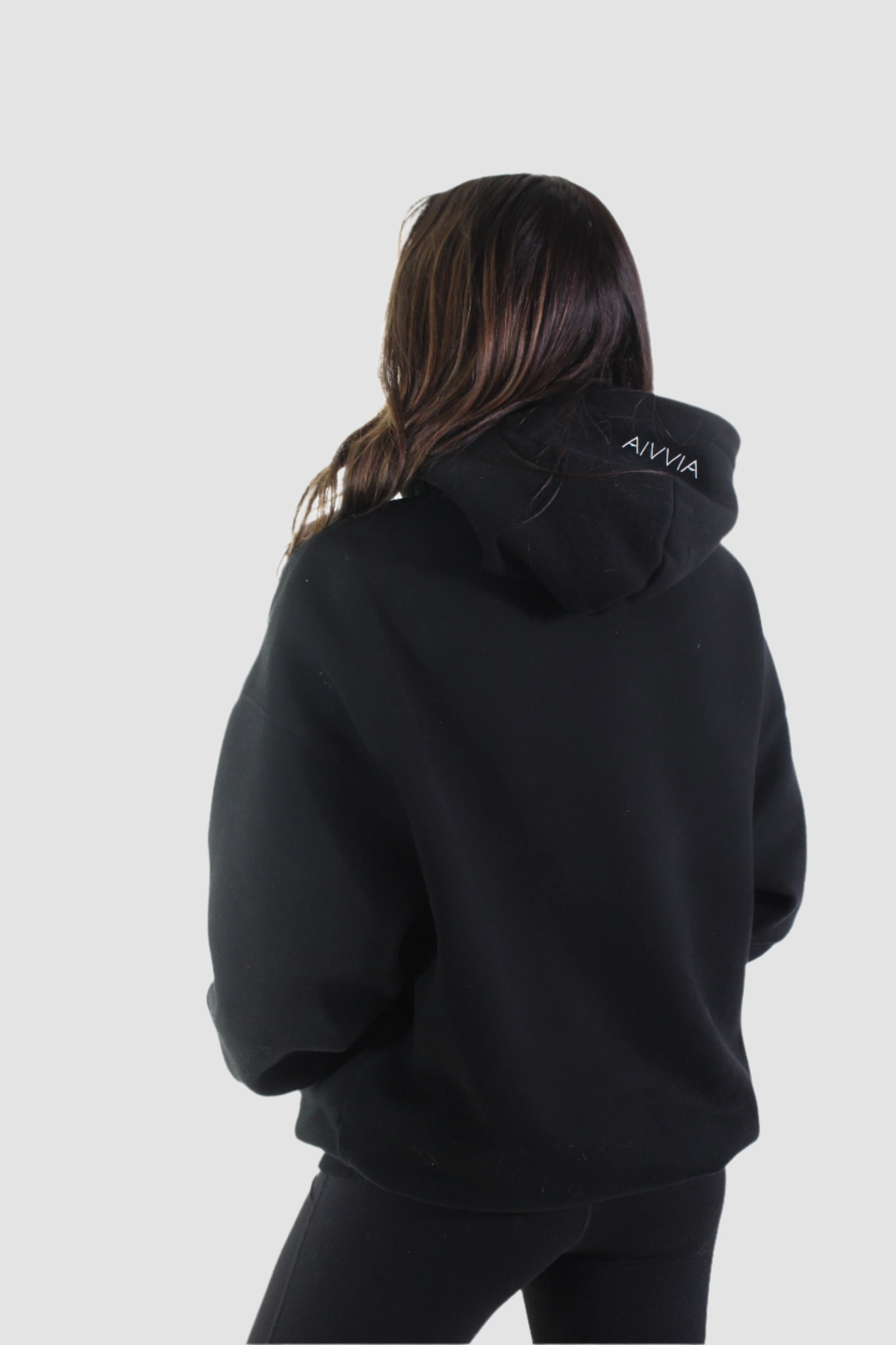 Back angled view of black Aivvia Athletics hoodie, cozy athletic pullover for women.