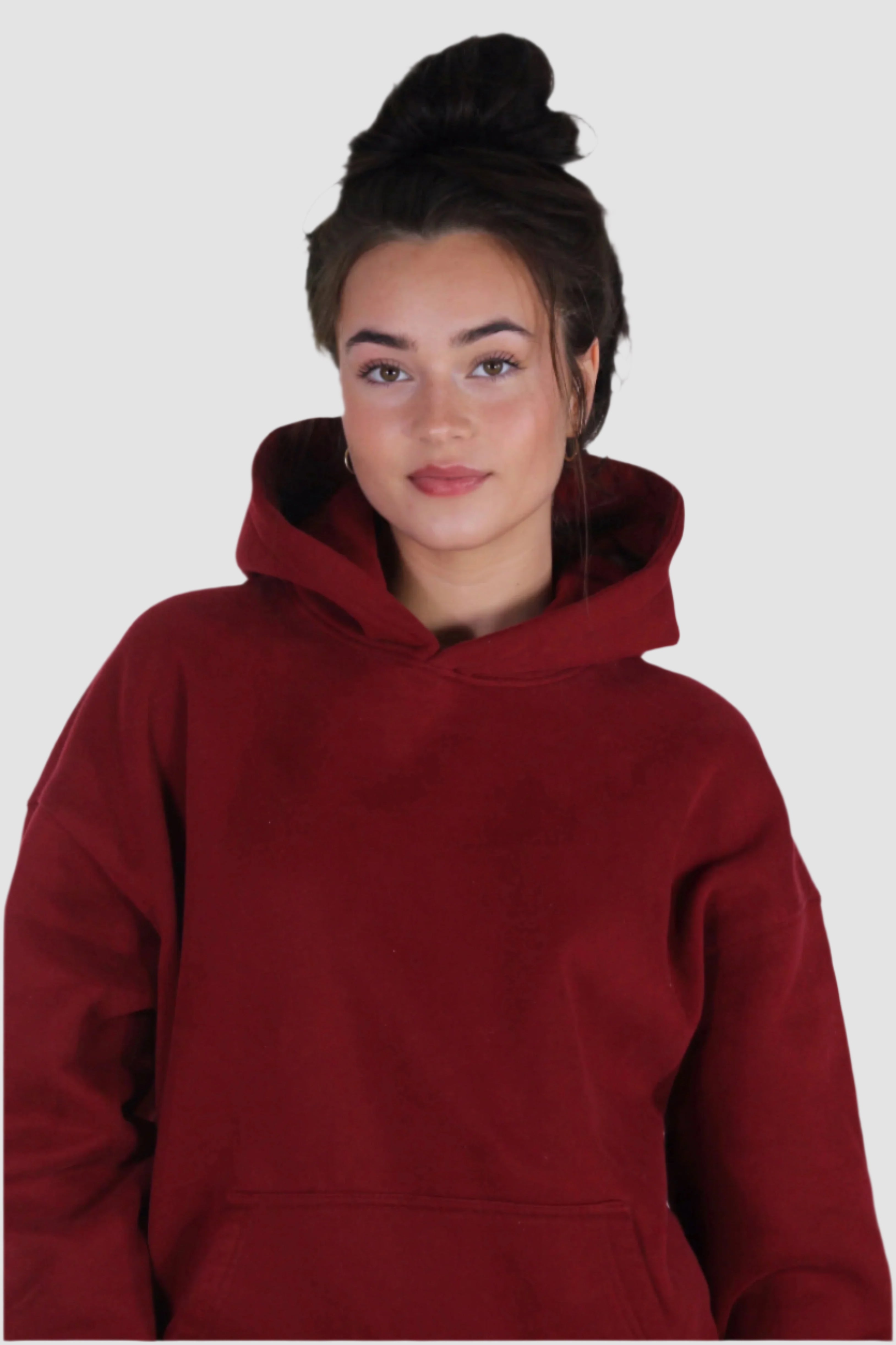 Woman in deep red Aivvia Athletics hoodie; warm, high-neck coverage with a cozy oversized silhouette.