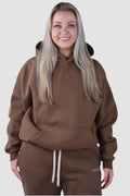 Warm brown Aivvia Athletics hoodie with front pocket and relaxed hood; soft fleece blend for all-day comfort.