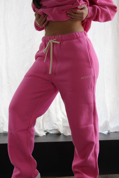 Bright pink Aivvia Athletics sweatpants styled with cropped hoodie; bold, confident, and ultra-soft for lounge or gym.
